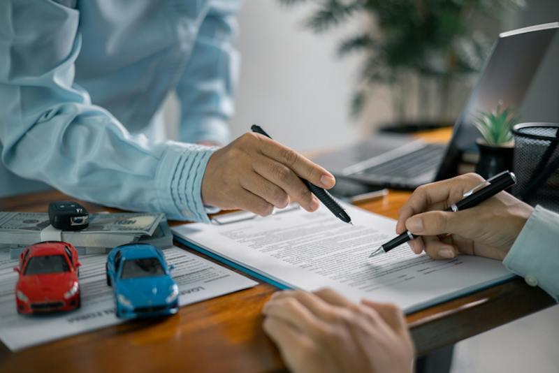 two people holding pens looking at insurance paper