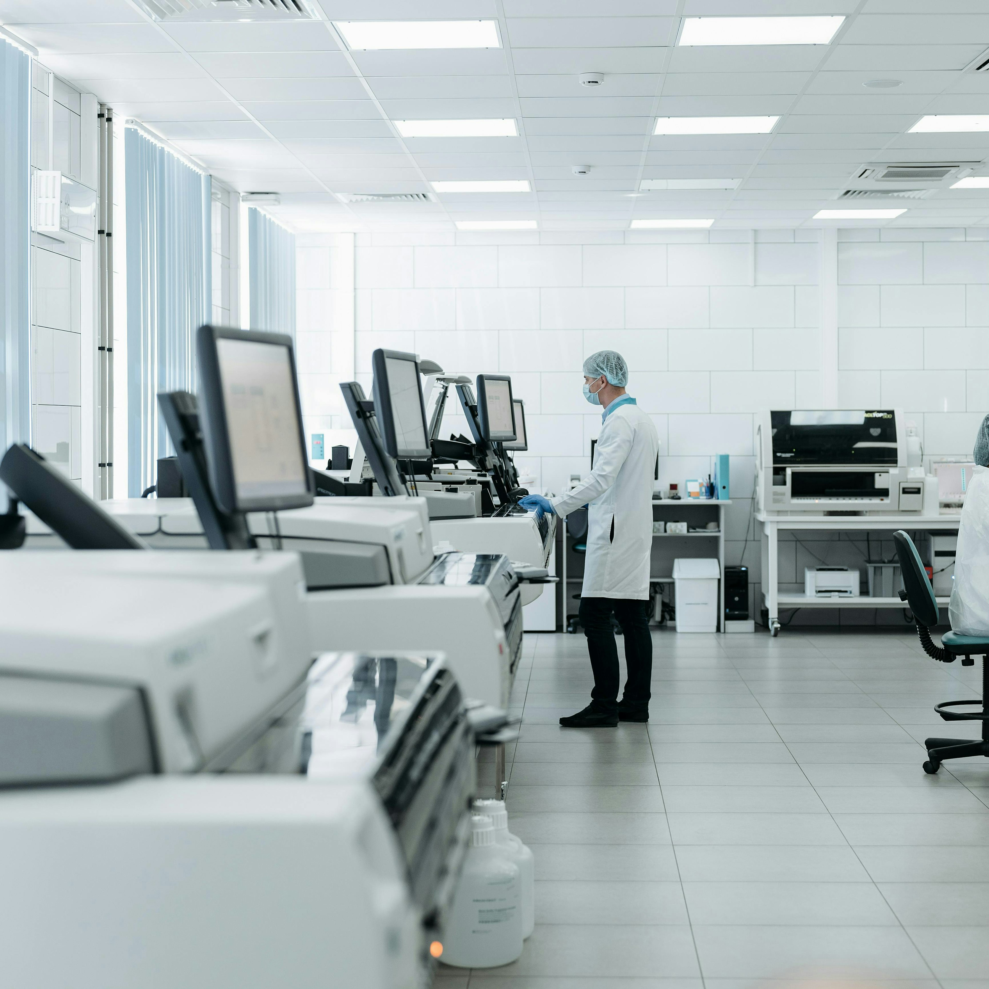 Le personnel de laboratoire travaillant sur des analyseurs et au microscope