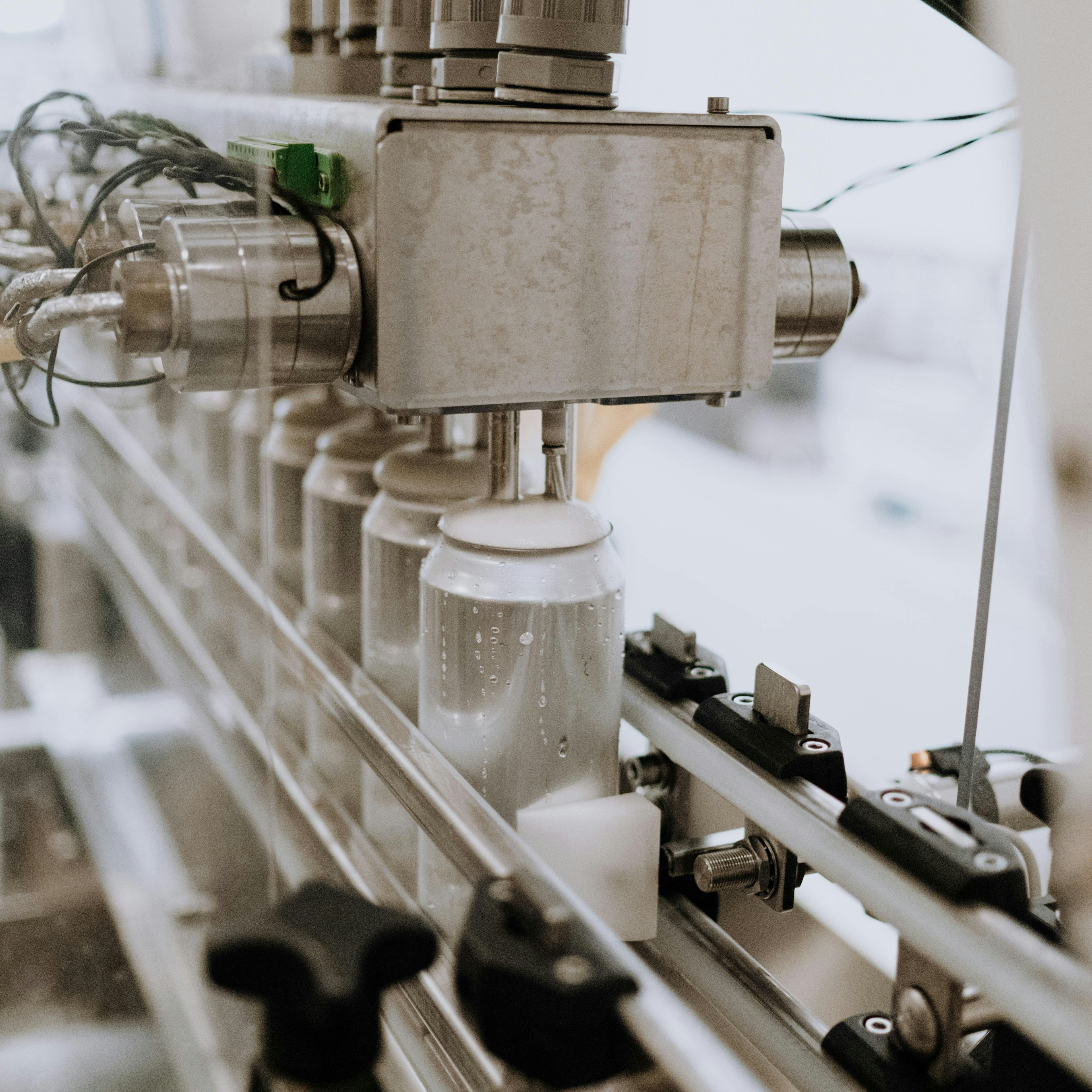 Machine de remplissage distribuant des canettes sur une chaîne de production de boissons