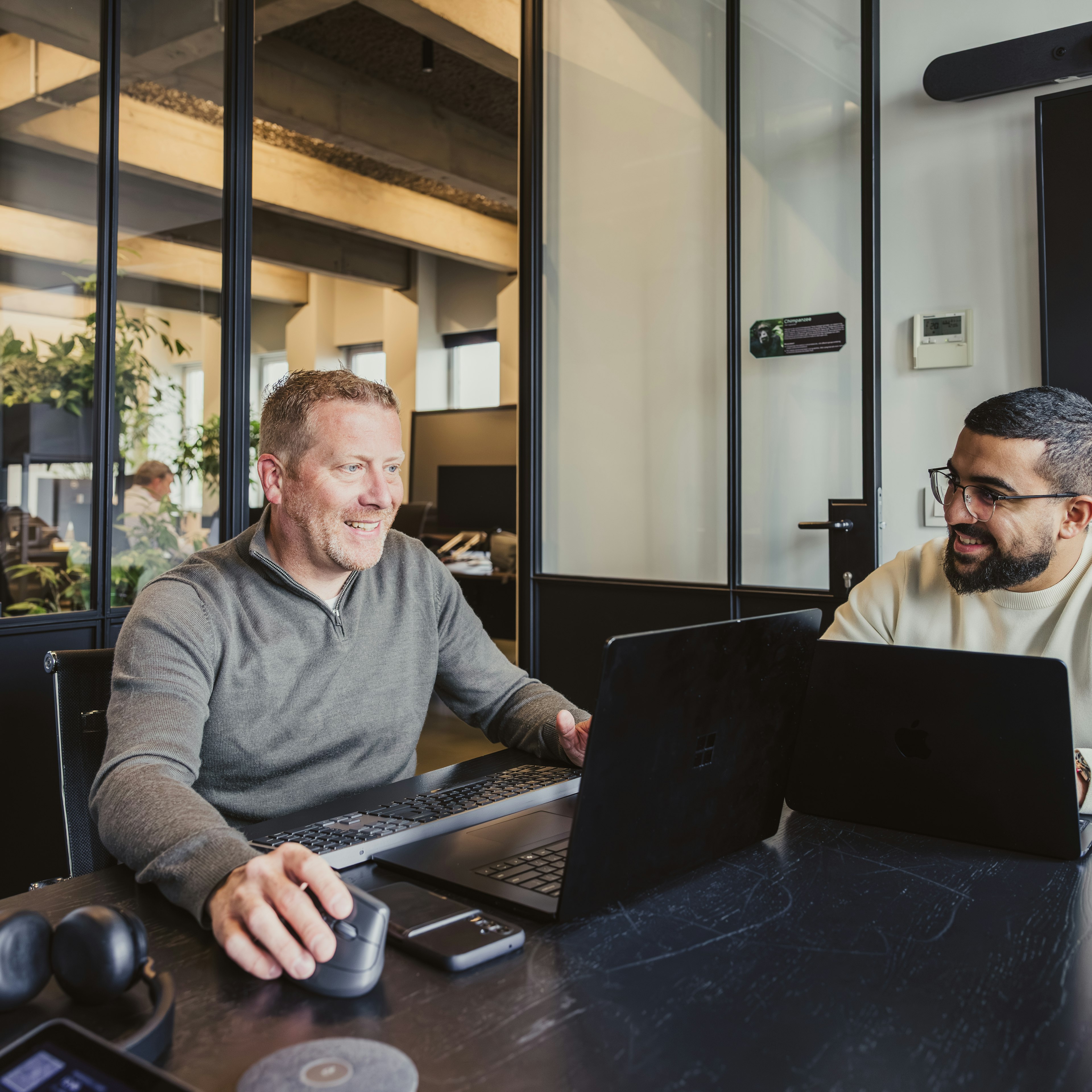 Two men working on laptops in a Dynapps office