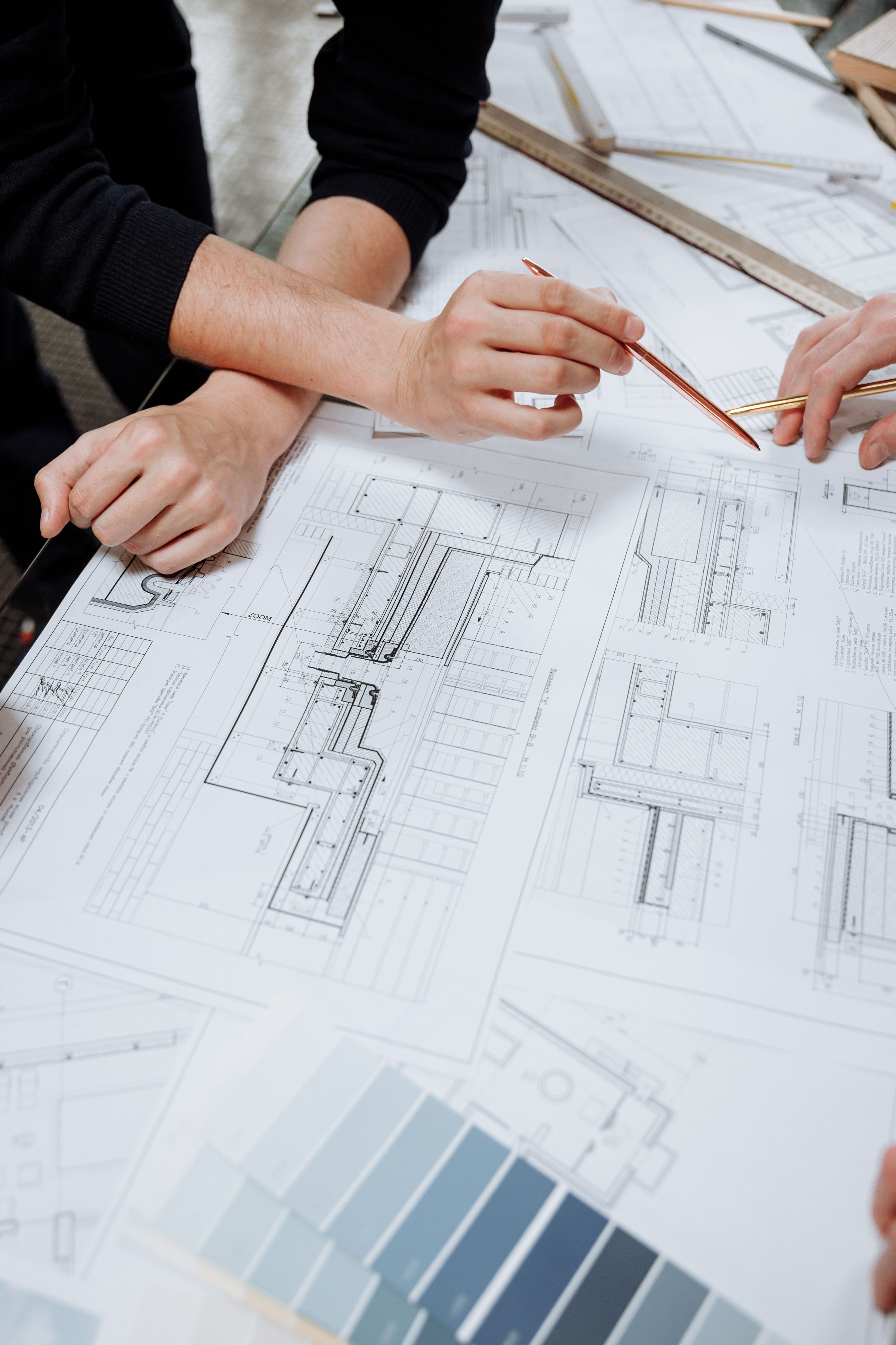 Two people reviewing technical drawings at a table