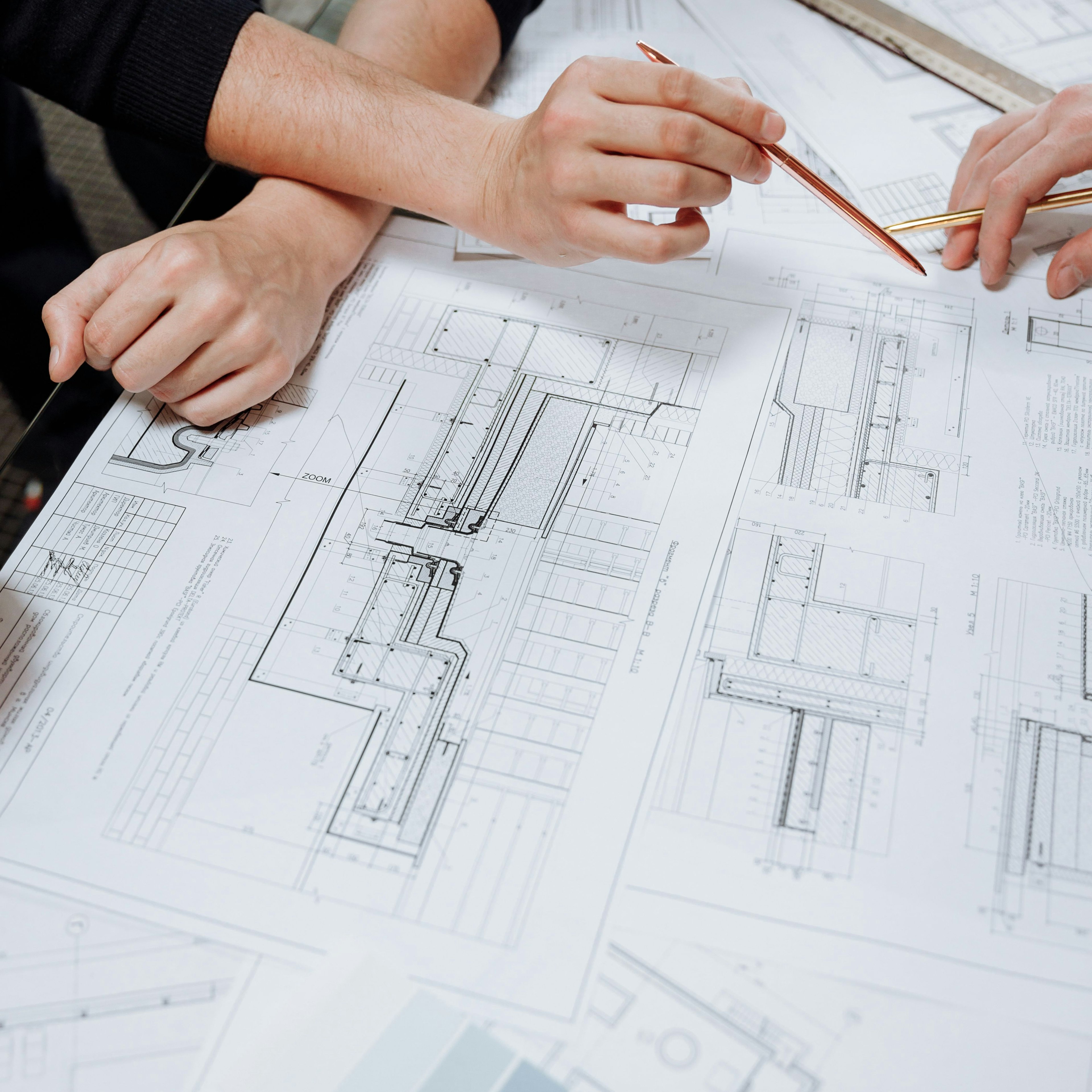 Two people reviewing technical drawings at a table