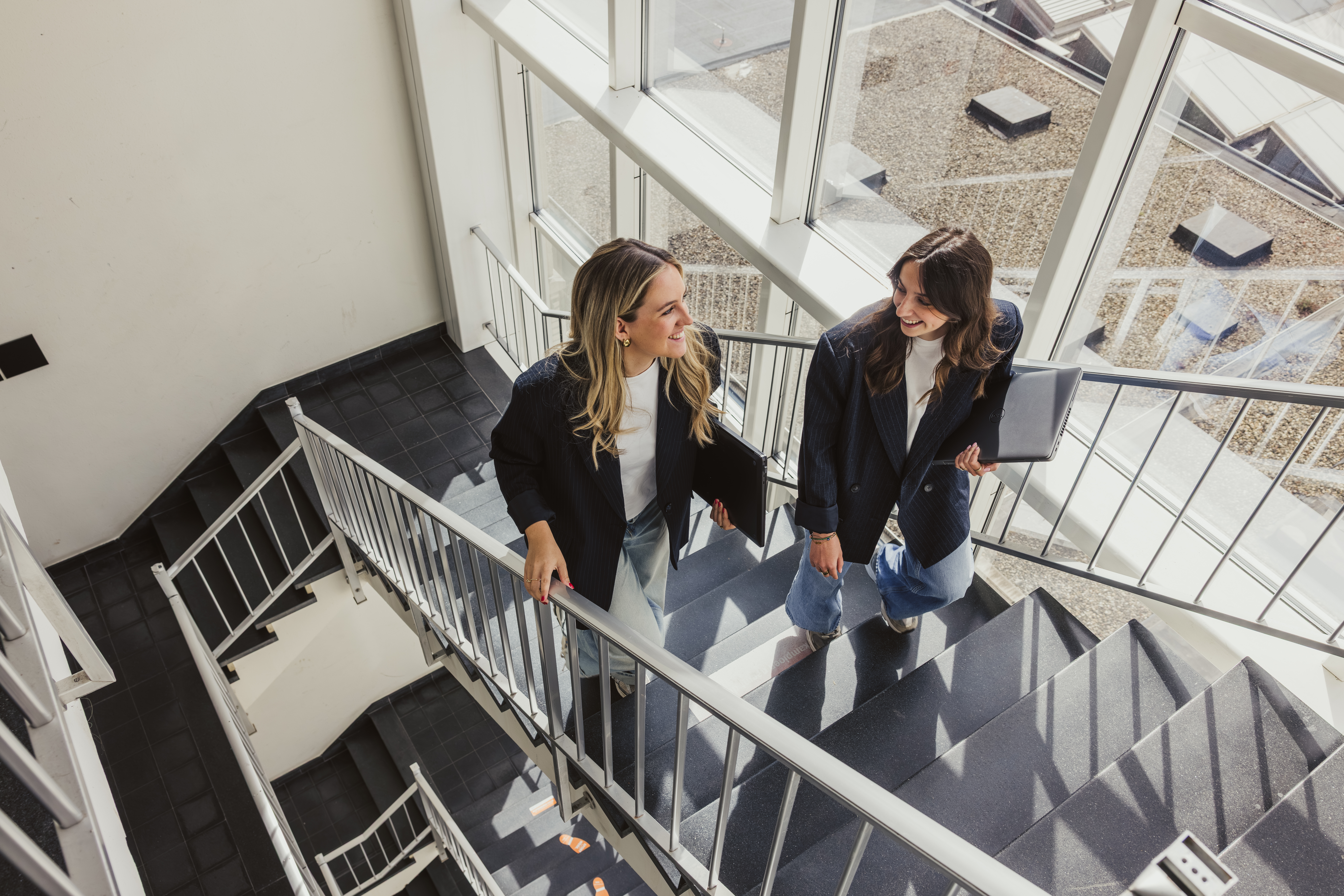 Two colleagues chatting on an office staircase