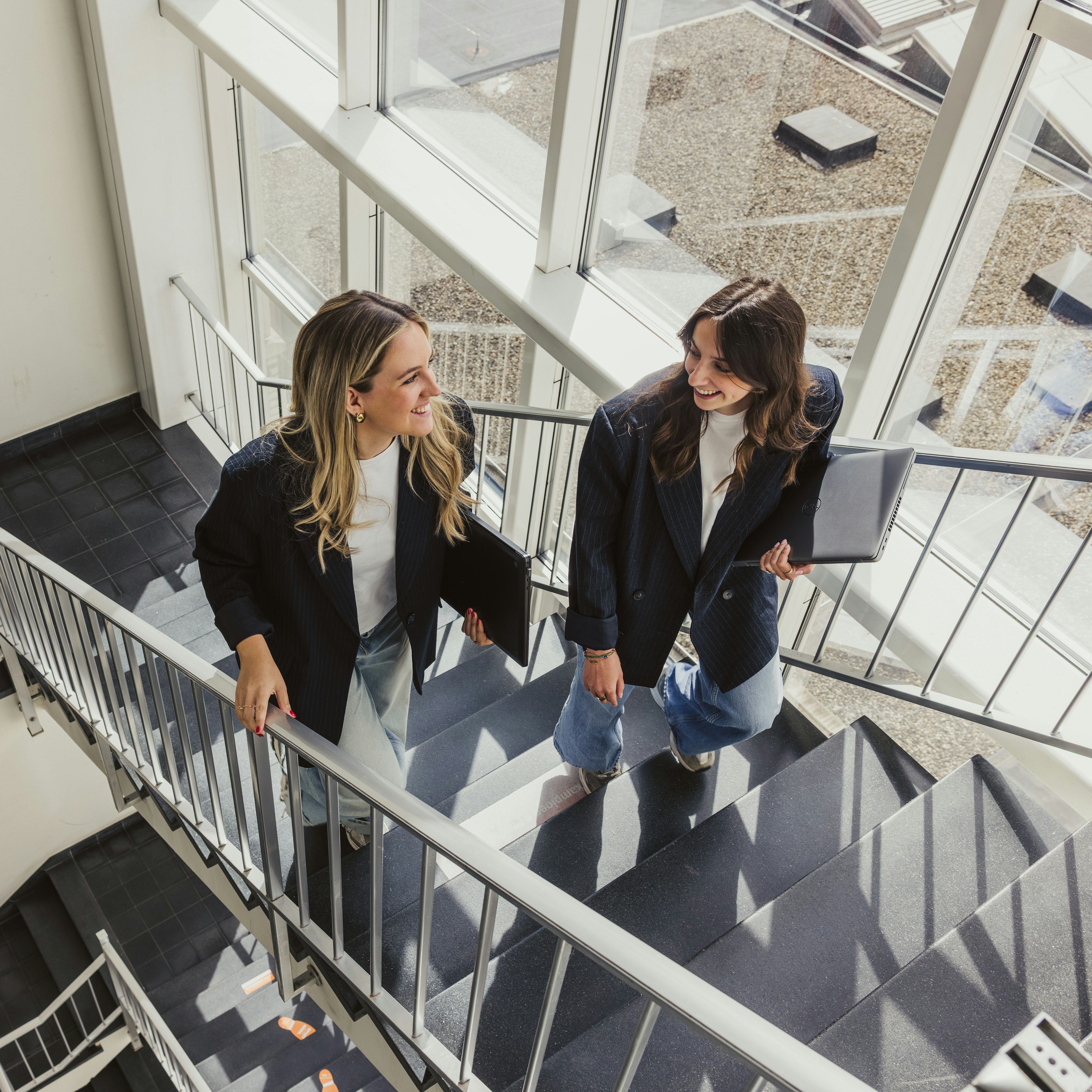 Deux collègues discutent dans l'escalier du bureau