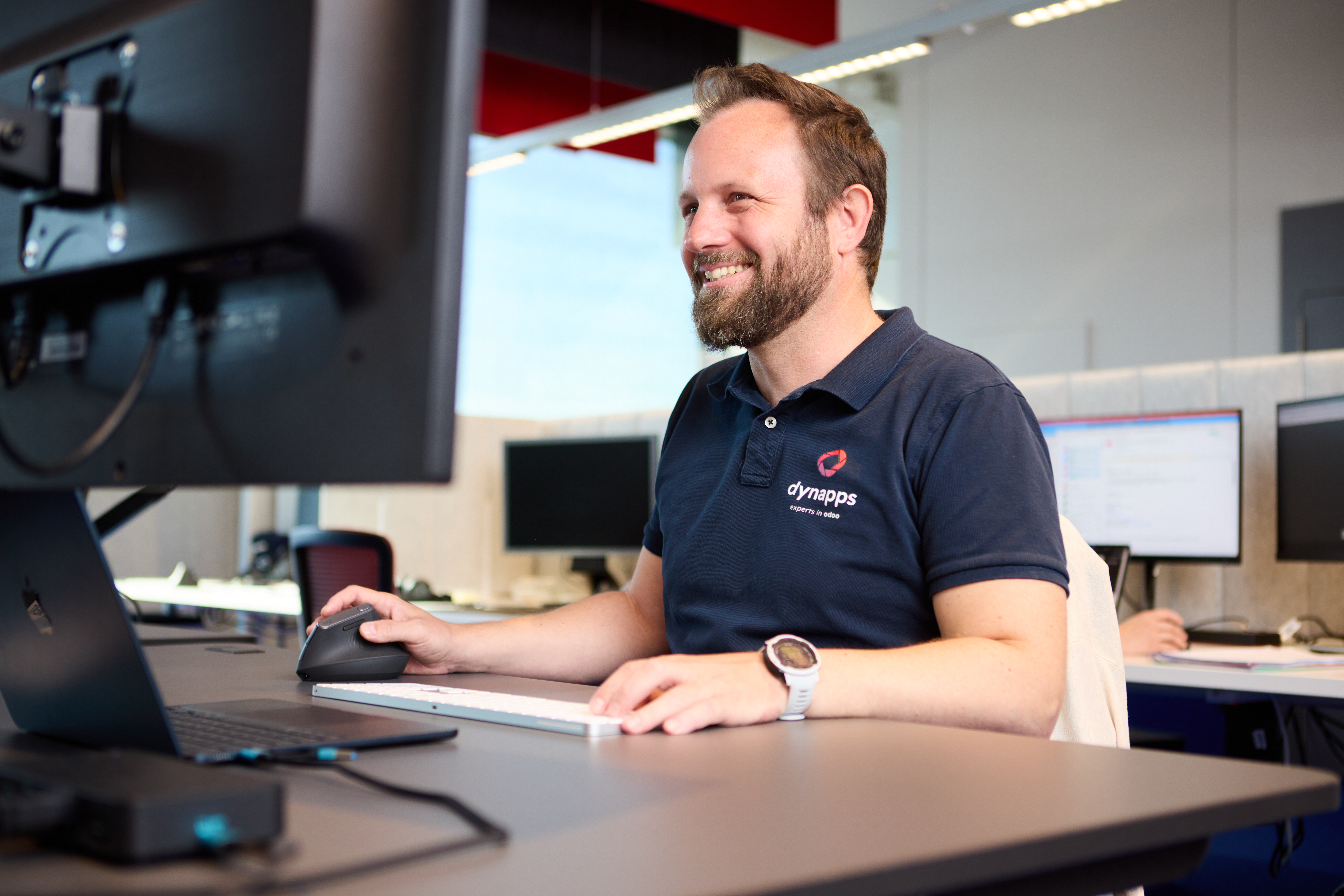Smiling Dynapps employee working at his desk