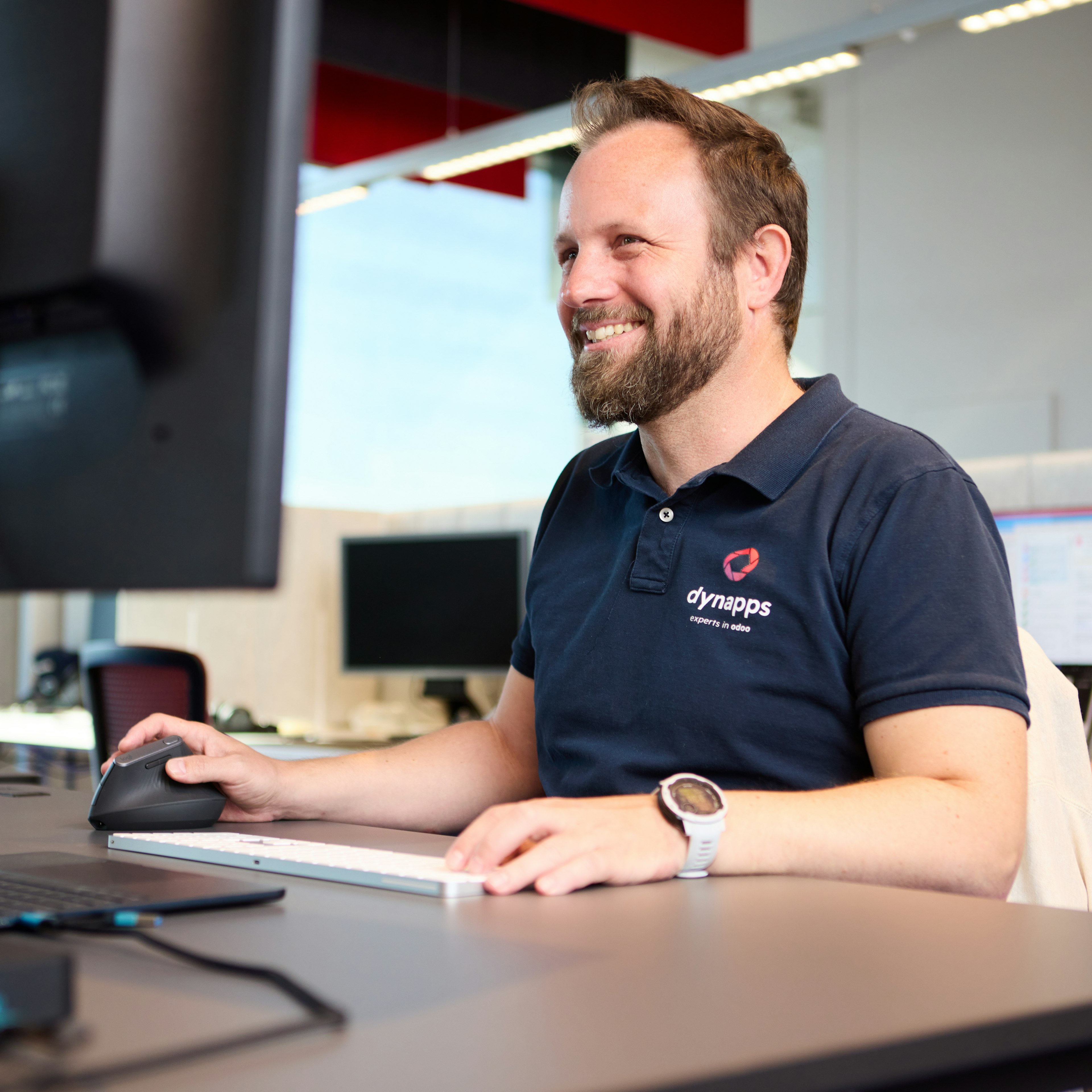 Smiling Dynapps employee working at his desk