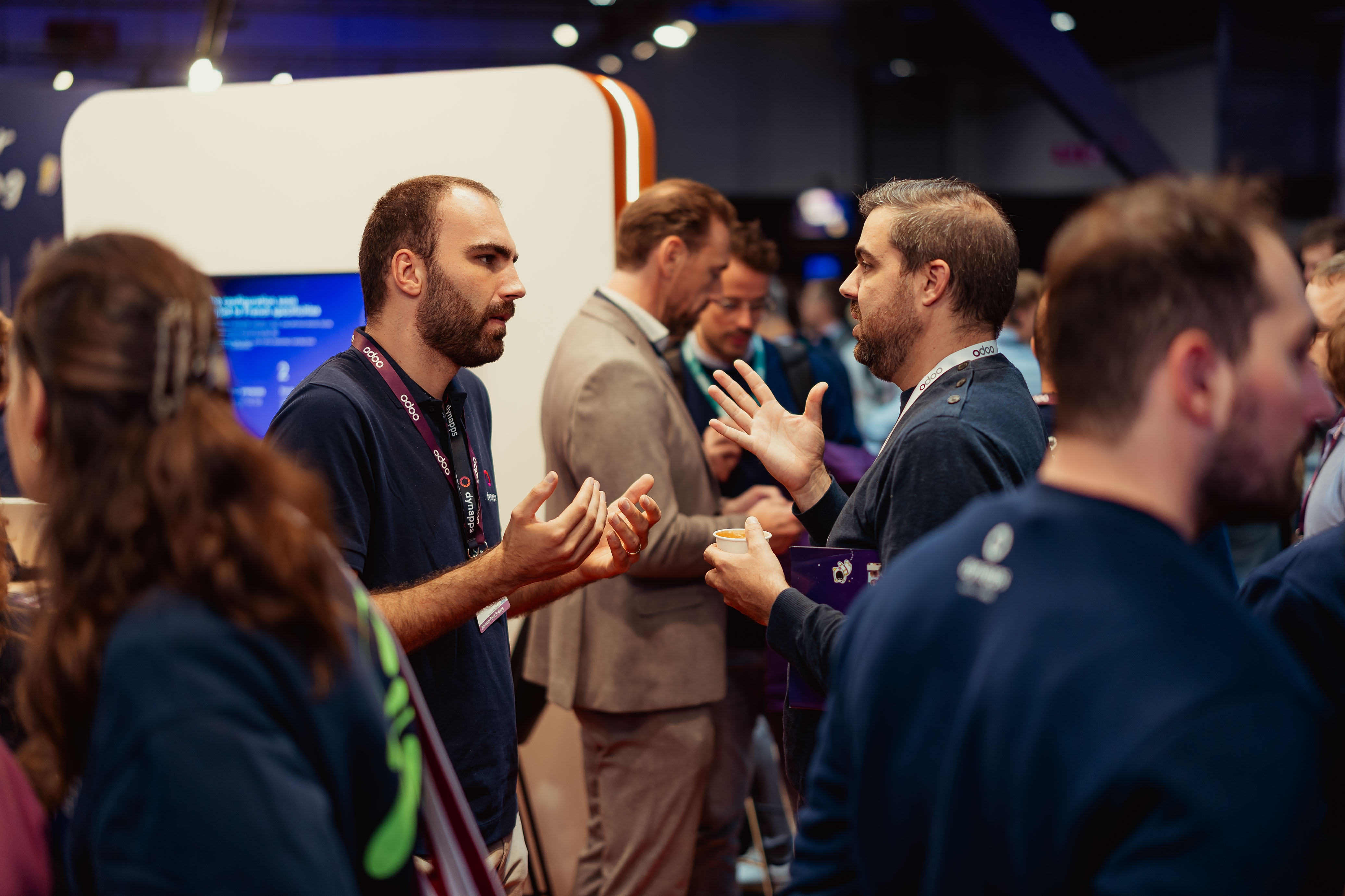 Two men in deep conversation at an Odoo event