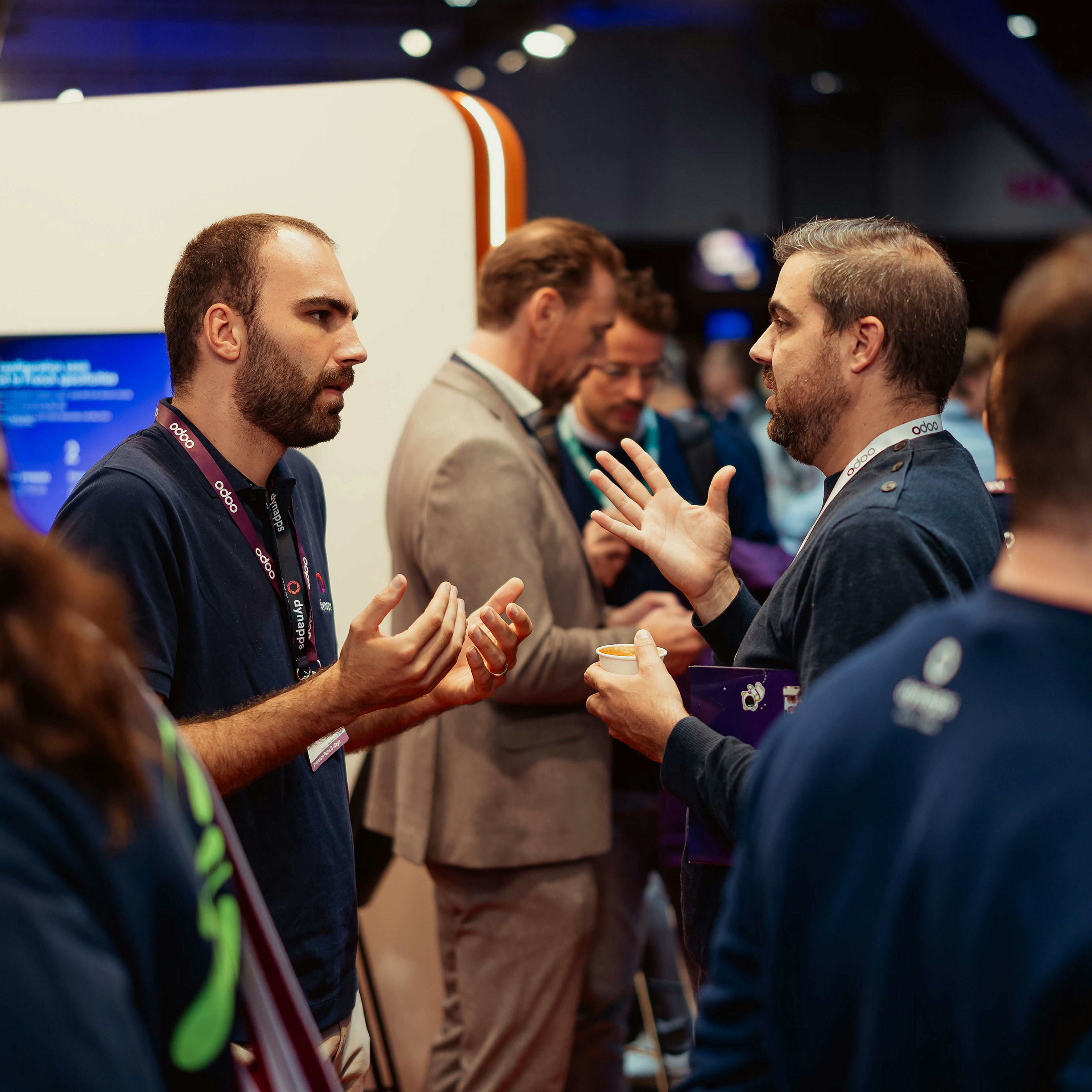 Two men in deep conversation at an Odoo event