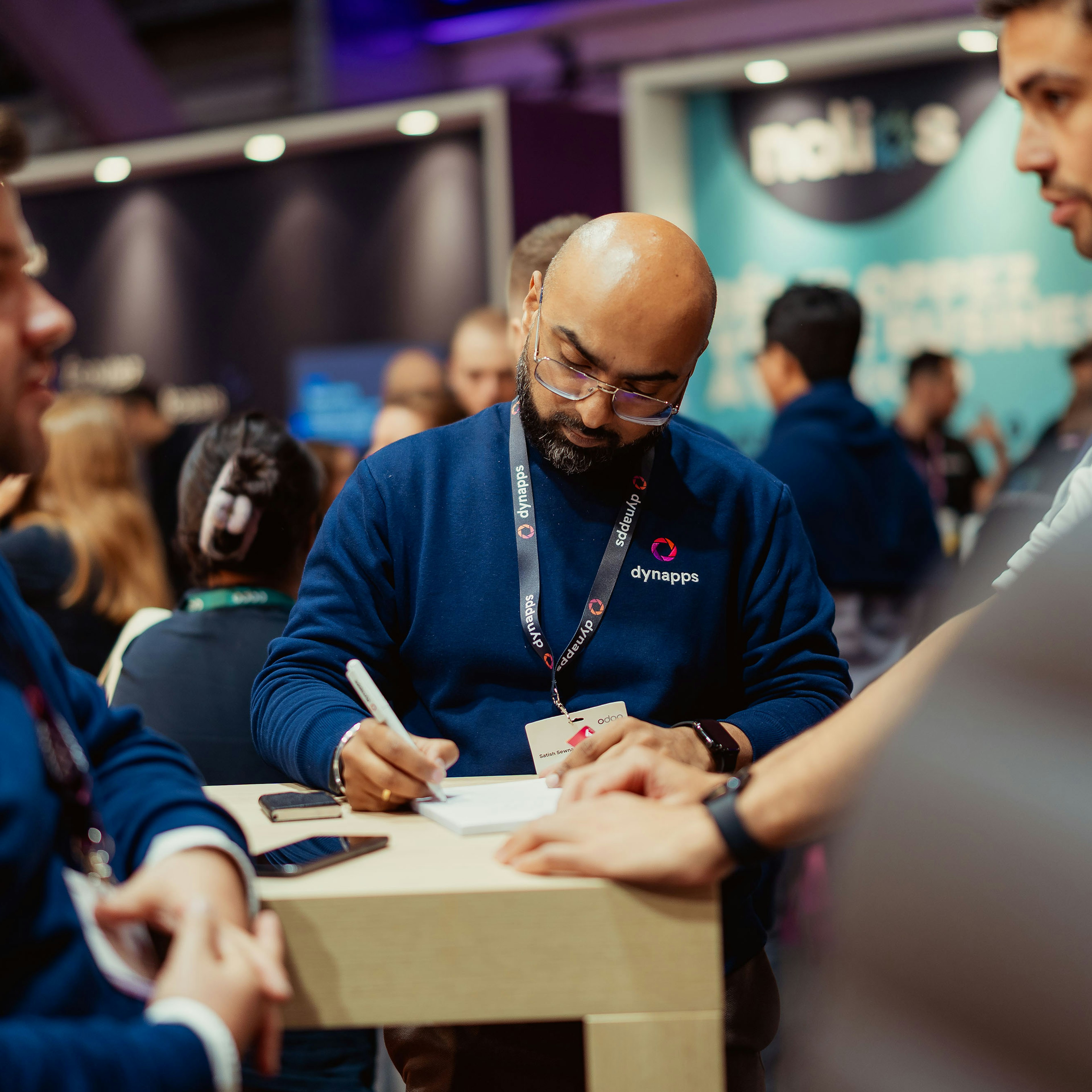 Dynapps consultant taking notes for a visitor at an event