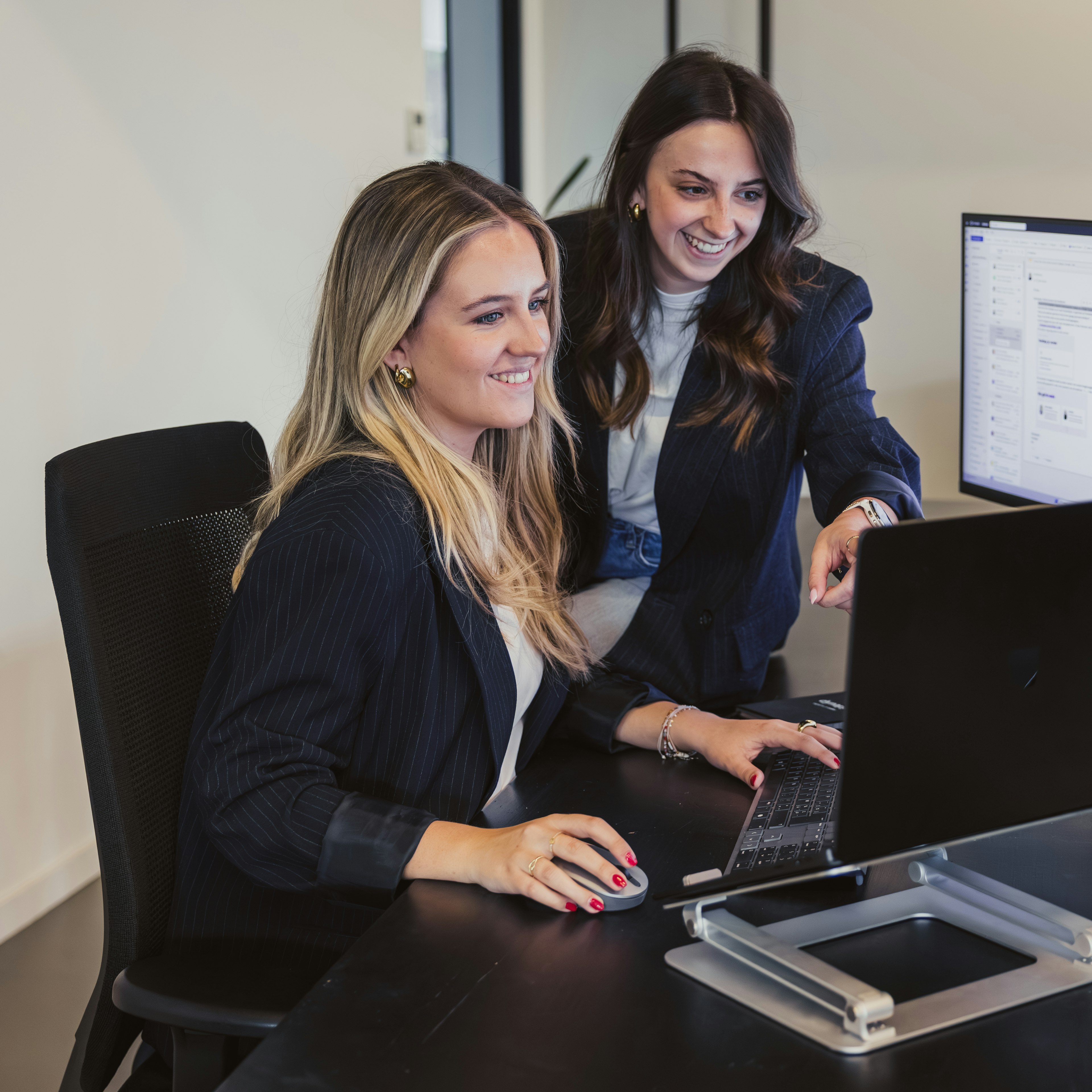Two woman reviewing software on a desk