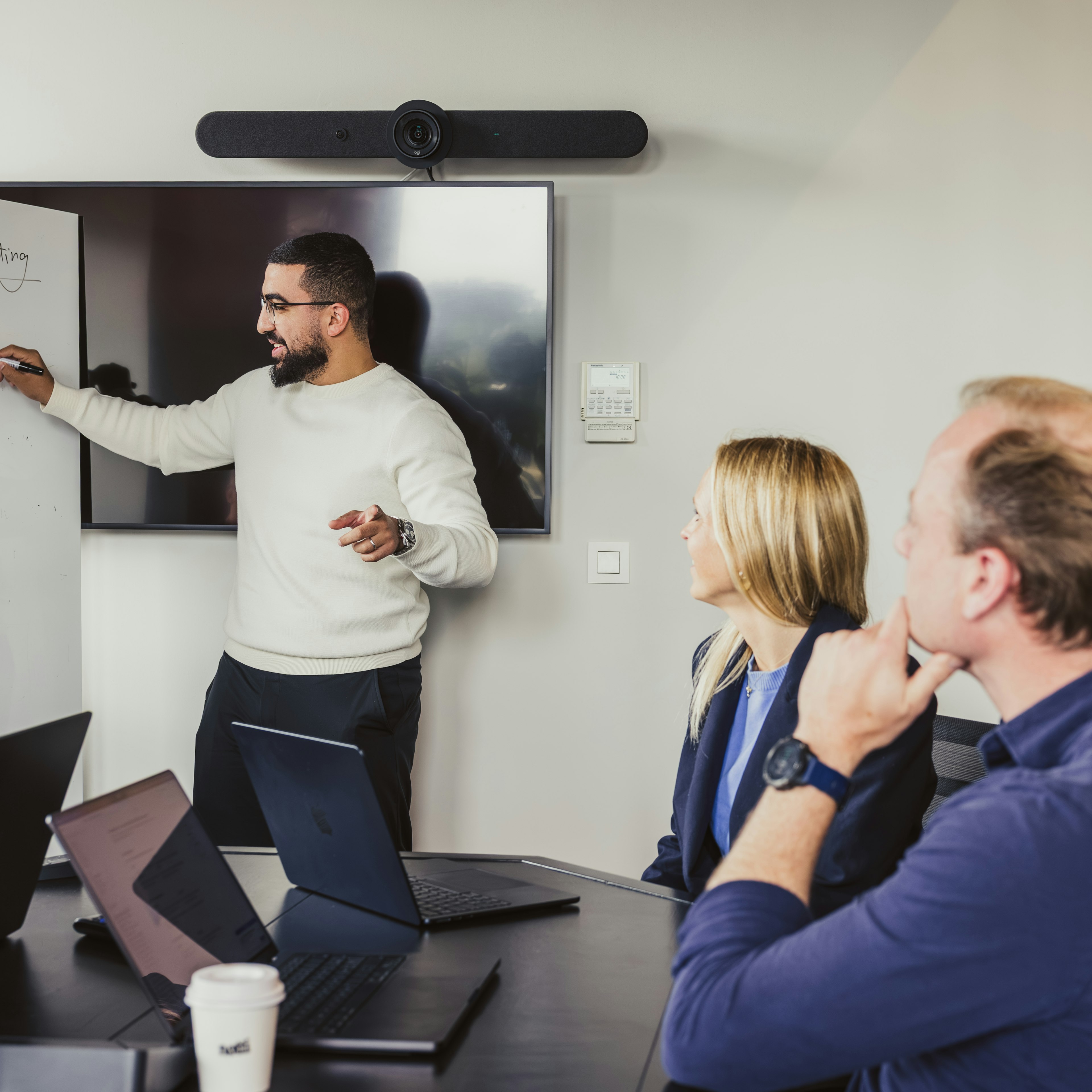Consultant pointing at whiteboard in a Dynapps sales meeting