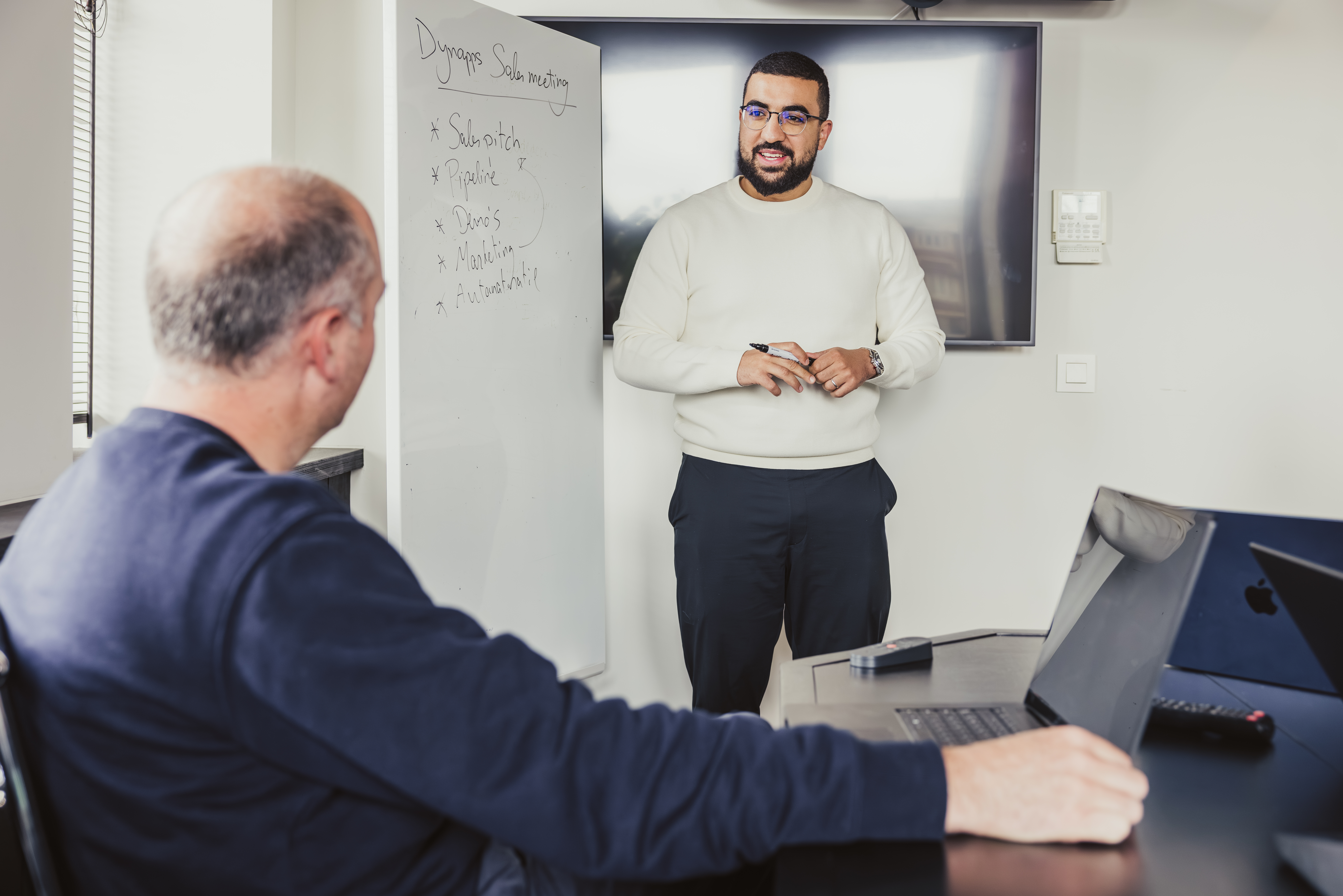 Speaker presenting agenda points at a Dynapps sales meeting