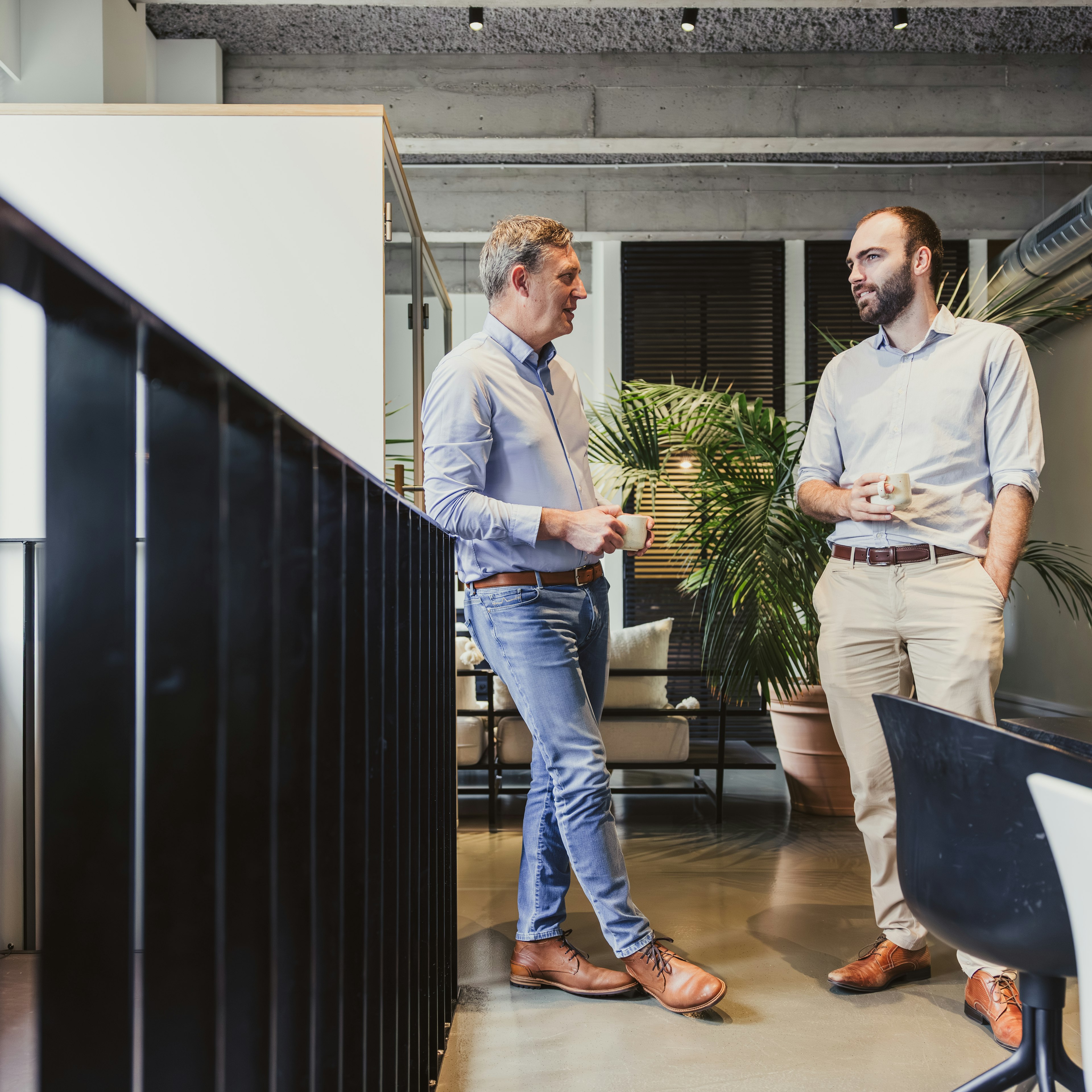 Deux collègues discutant autour d'un café dans un bureau moderne