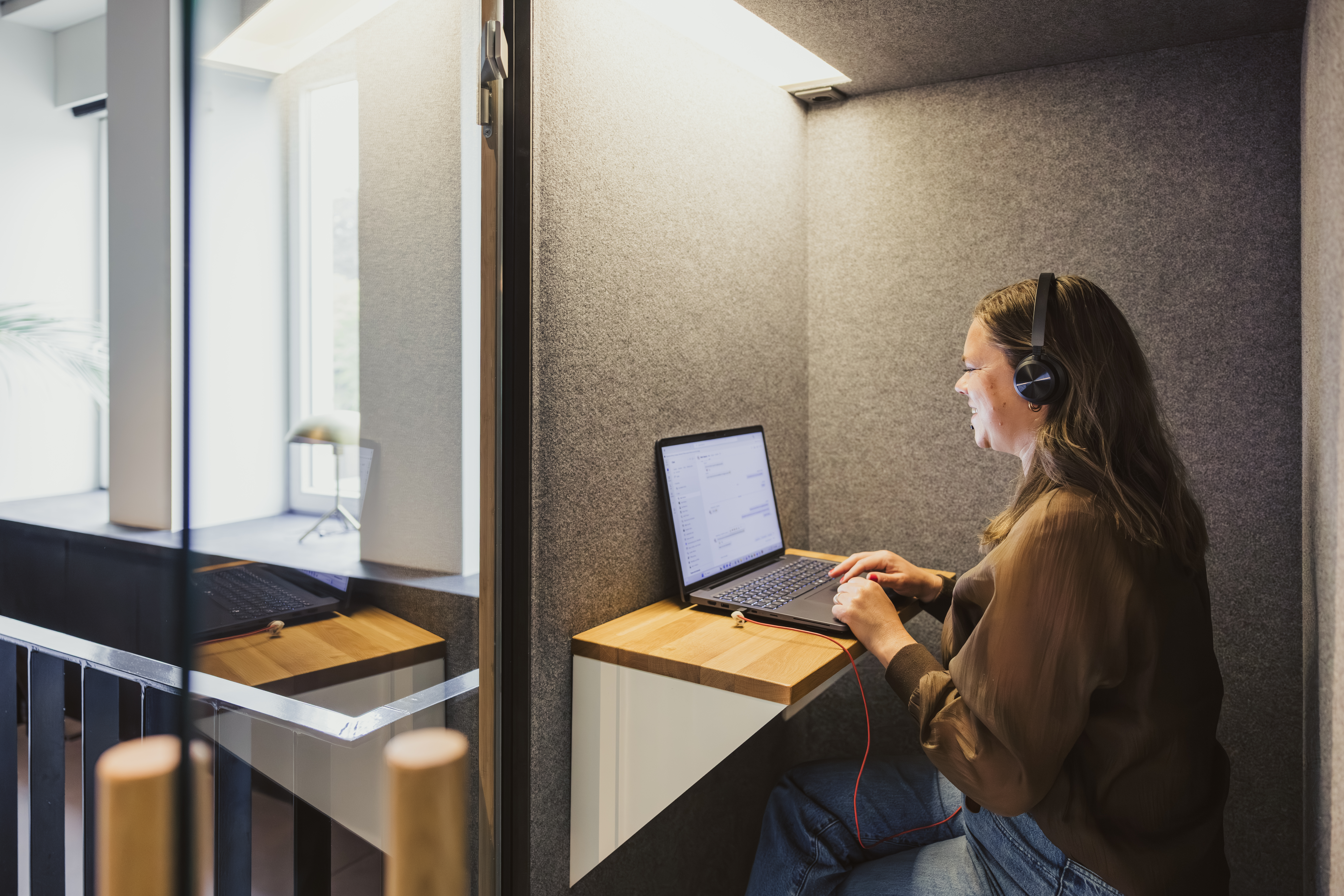 Un employé au téléphone avec un casque dans une cabine insonorisée