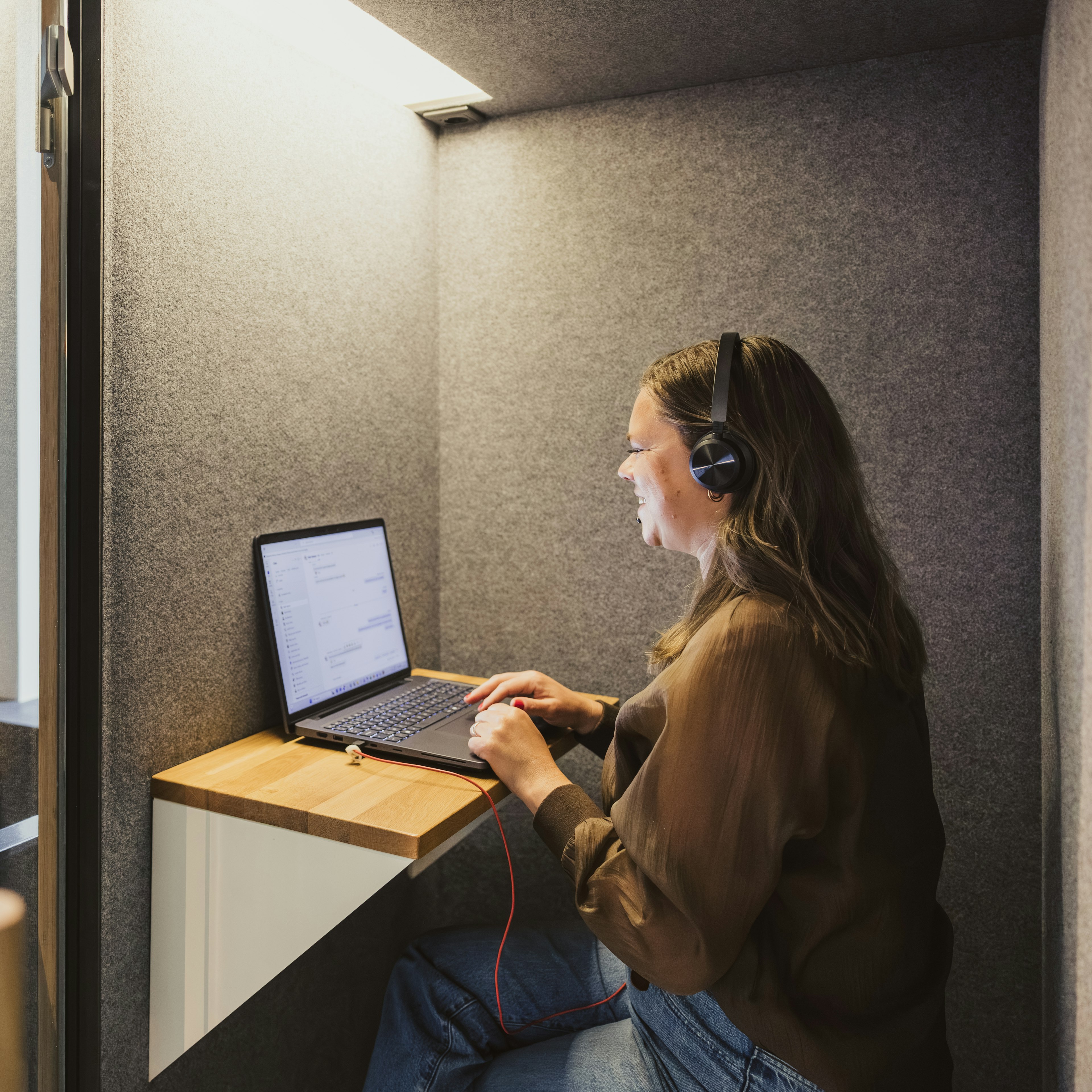 Un employé au téléphone avec un casque dans une cabine insonorisée