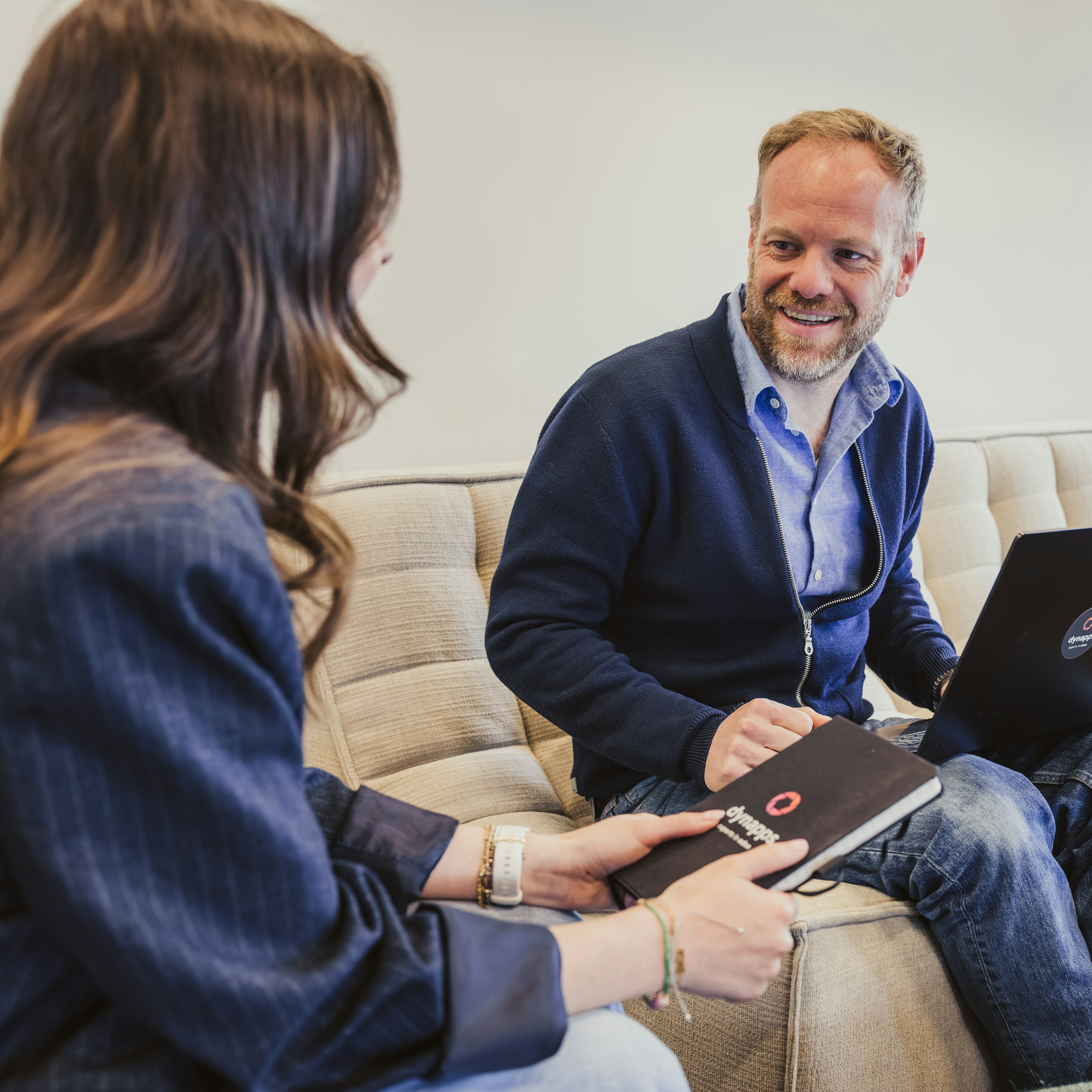 Colleagues with laptop and Dynapps notebook on a sofa