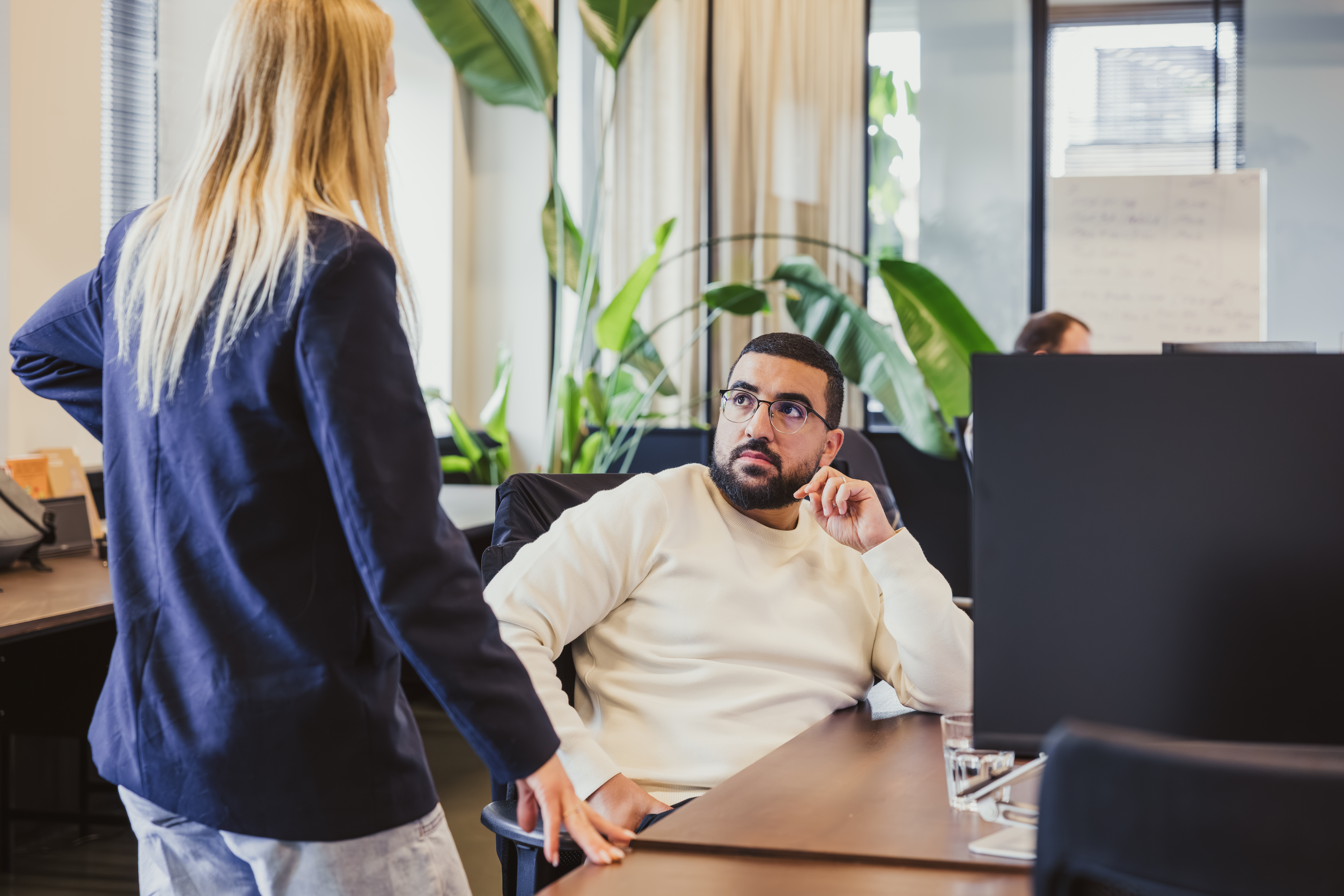 Two colleagues having a chat at an office desk
