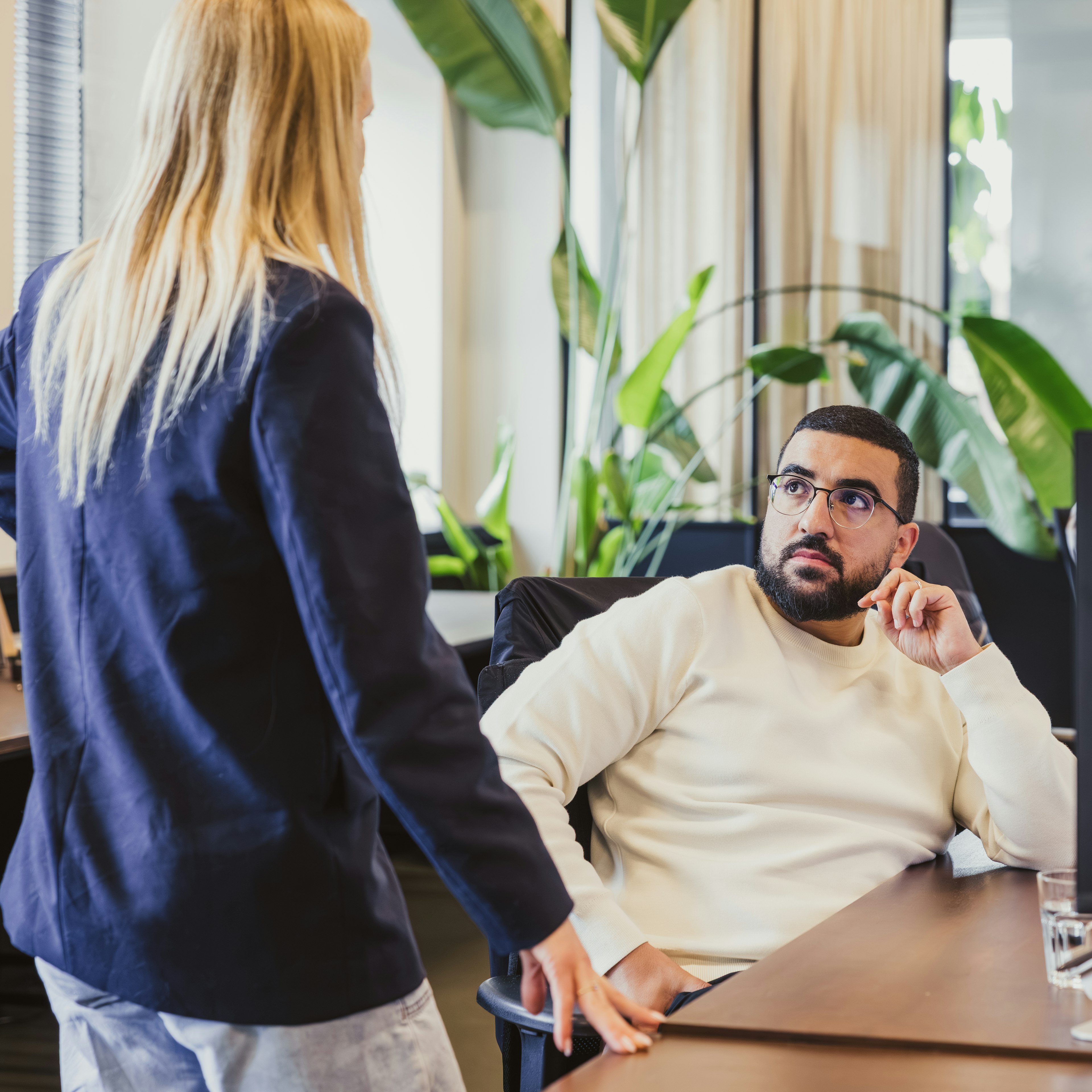 Two colleagues having a chat at an office desk