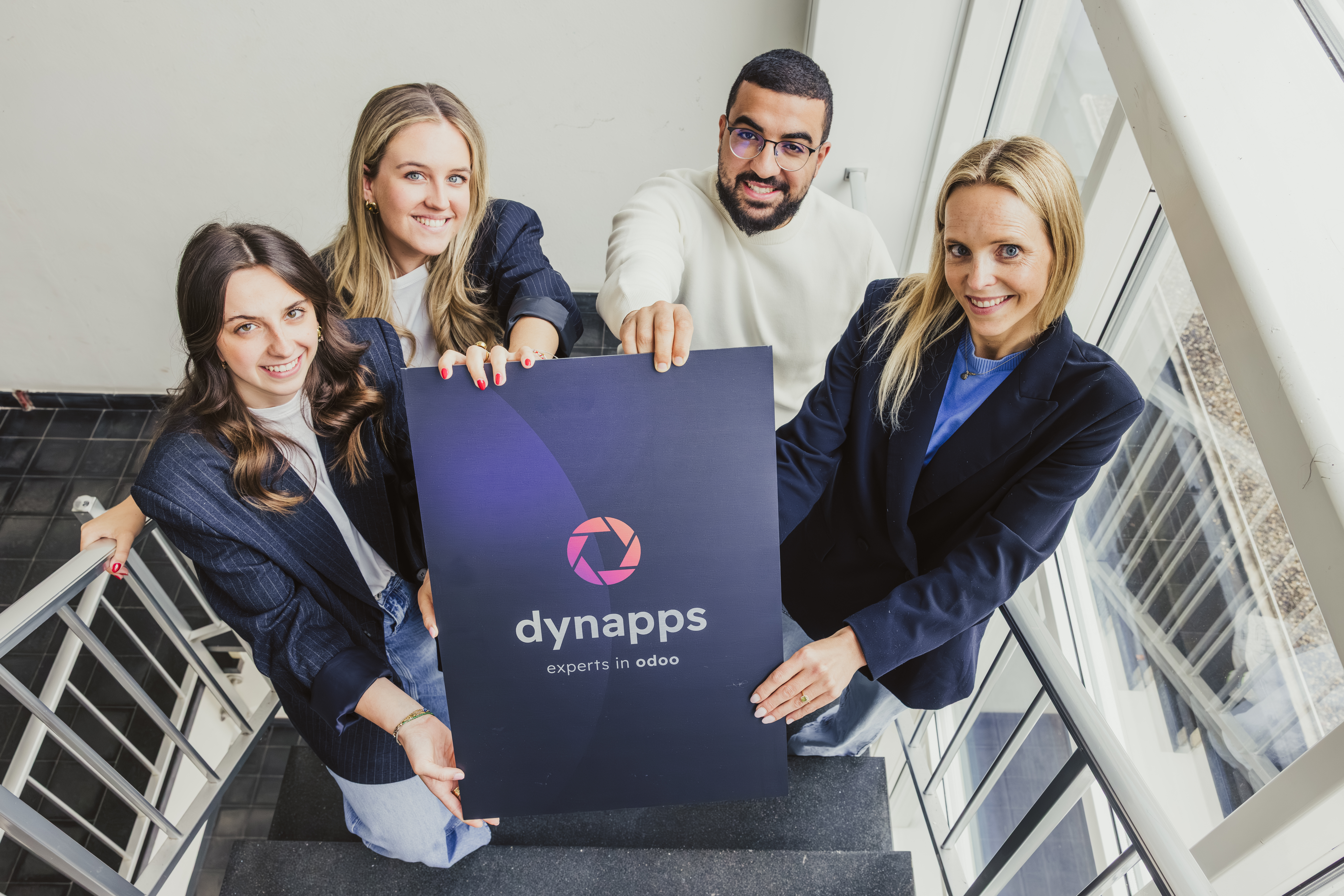 Equipo de Dynnaps, enseñado un poster con el logo