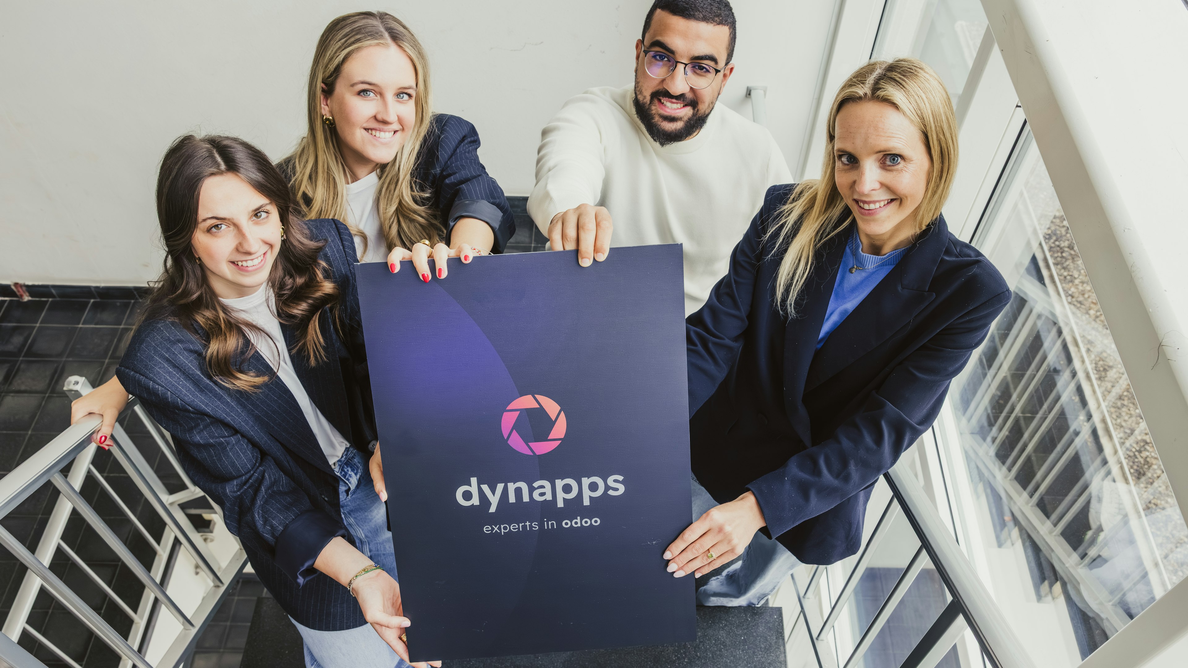 Equipo de Dynnaps, enseñado un poster con el logo