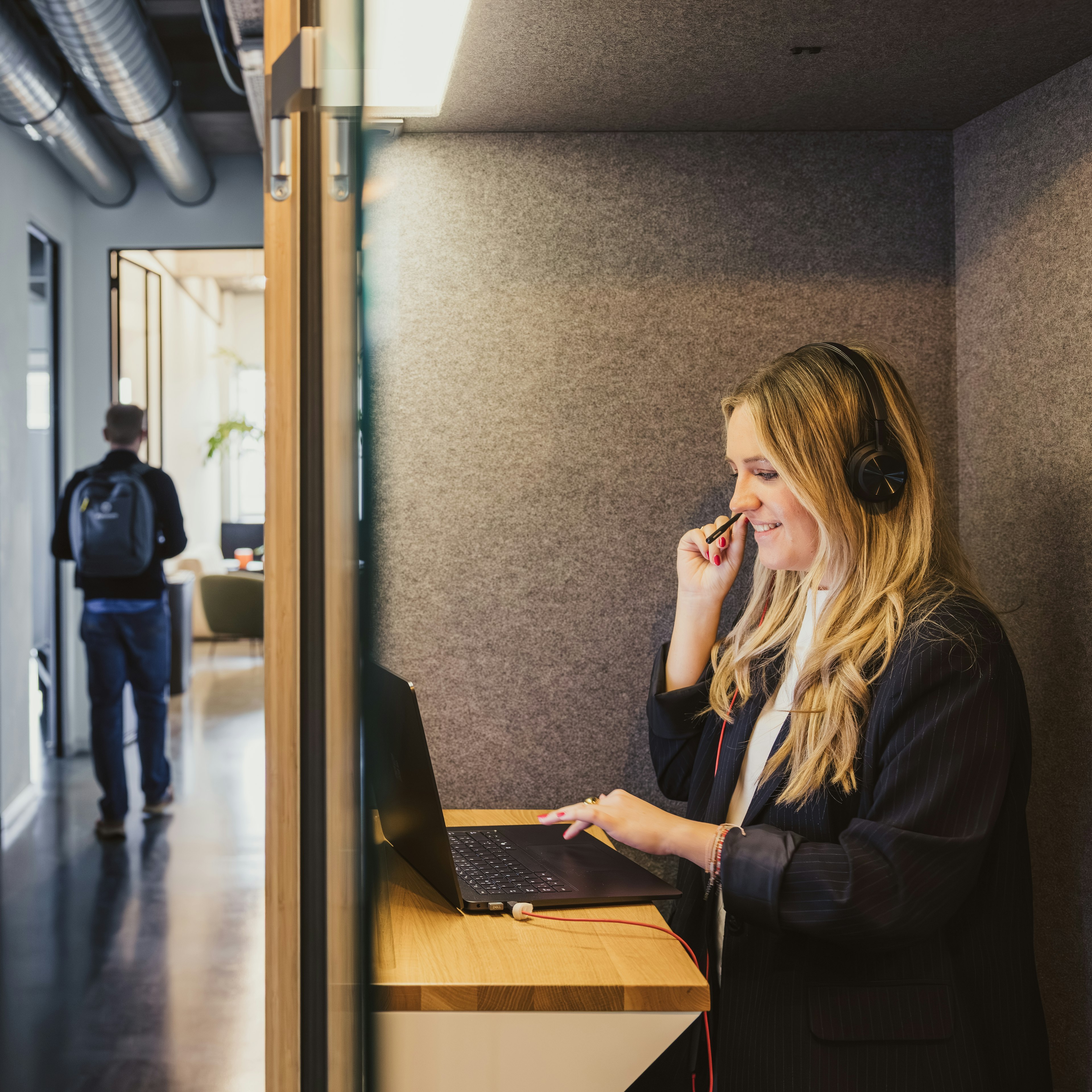 Consultant on a headset call at a standing desk booth