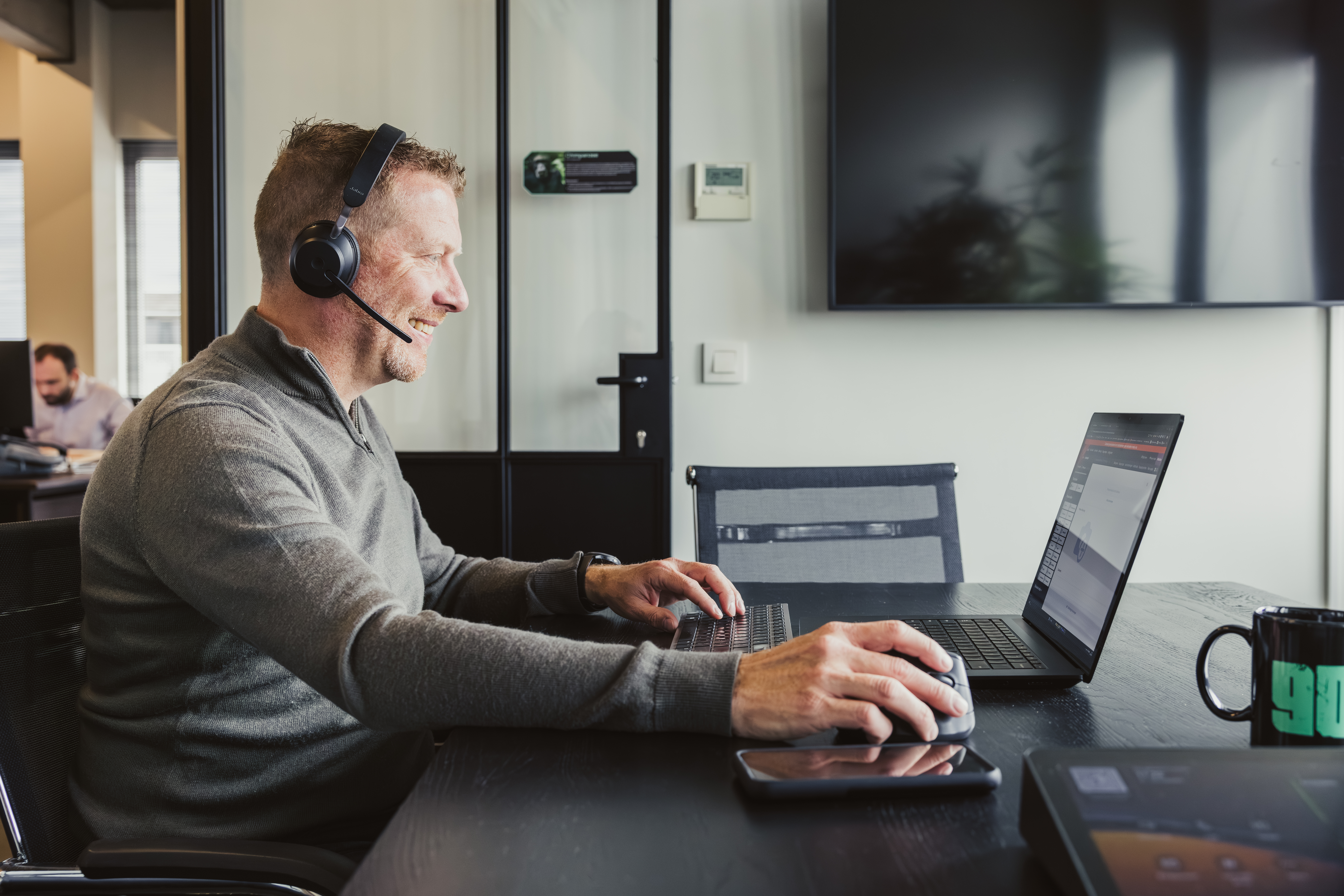 Consultant on a headset call using laptop and mouse