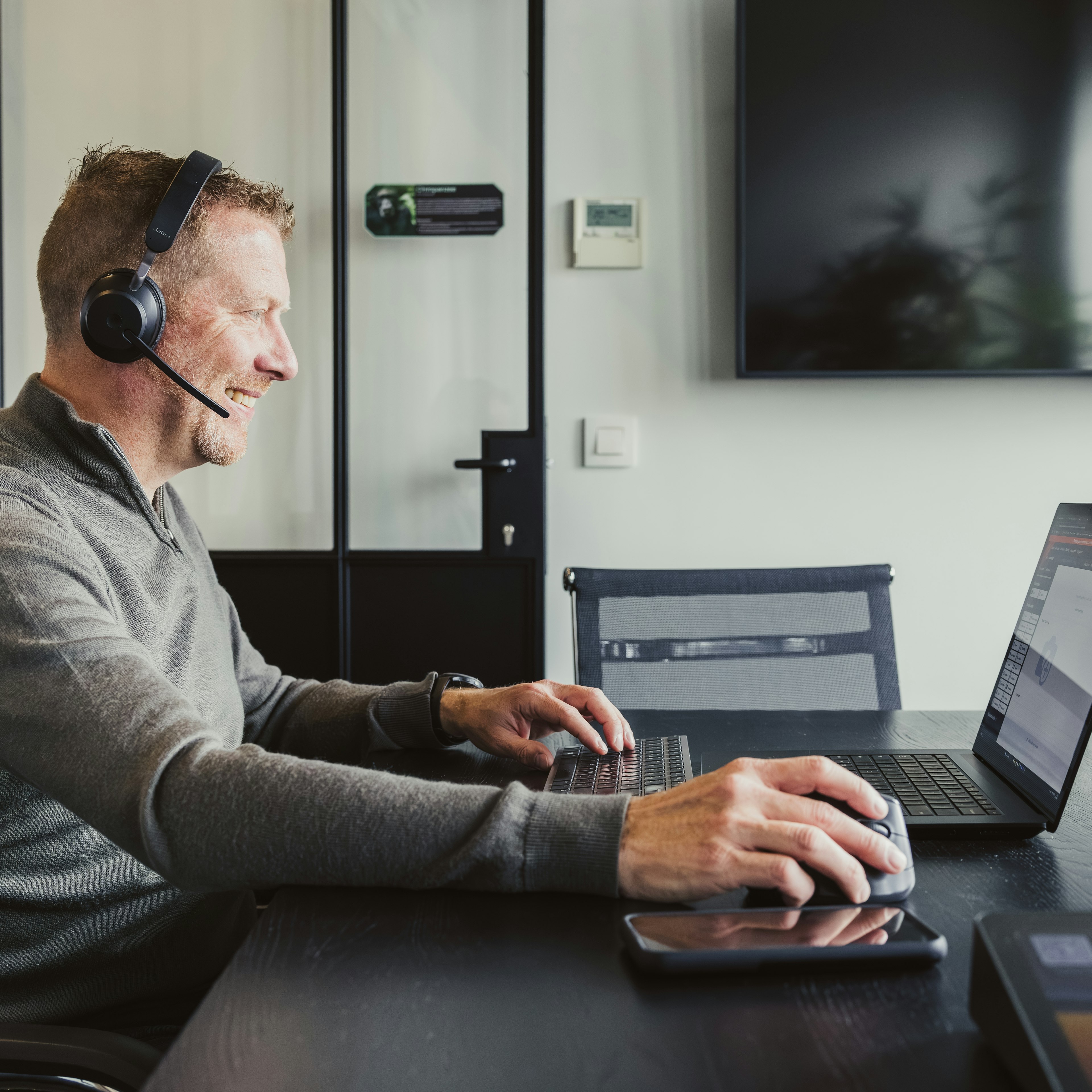 Consultant on a headset call using laptop and mouse