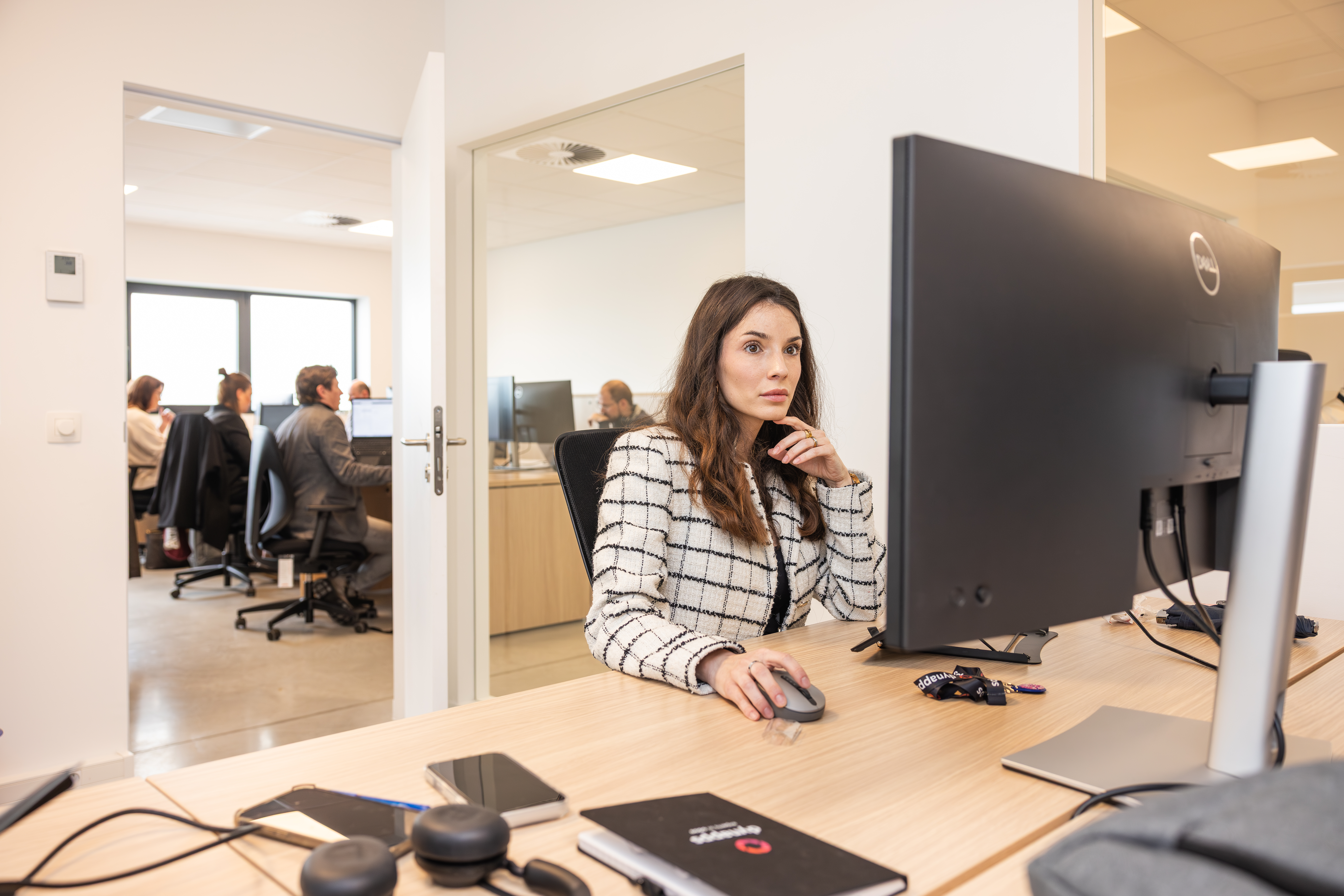 Une femme travaillant devant son écran dans un bureau en open space