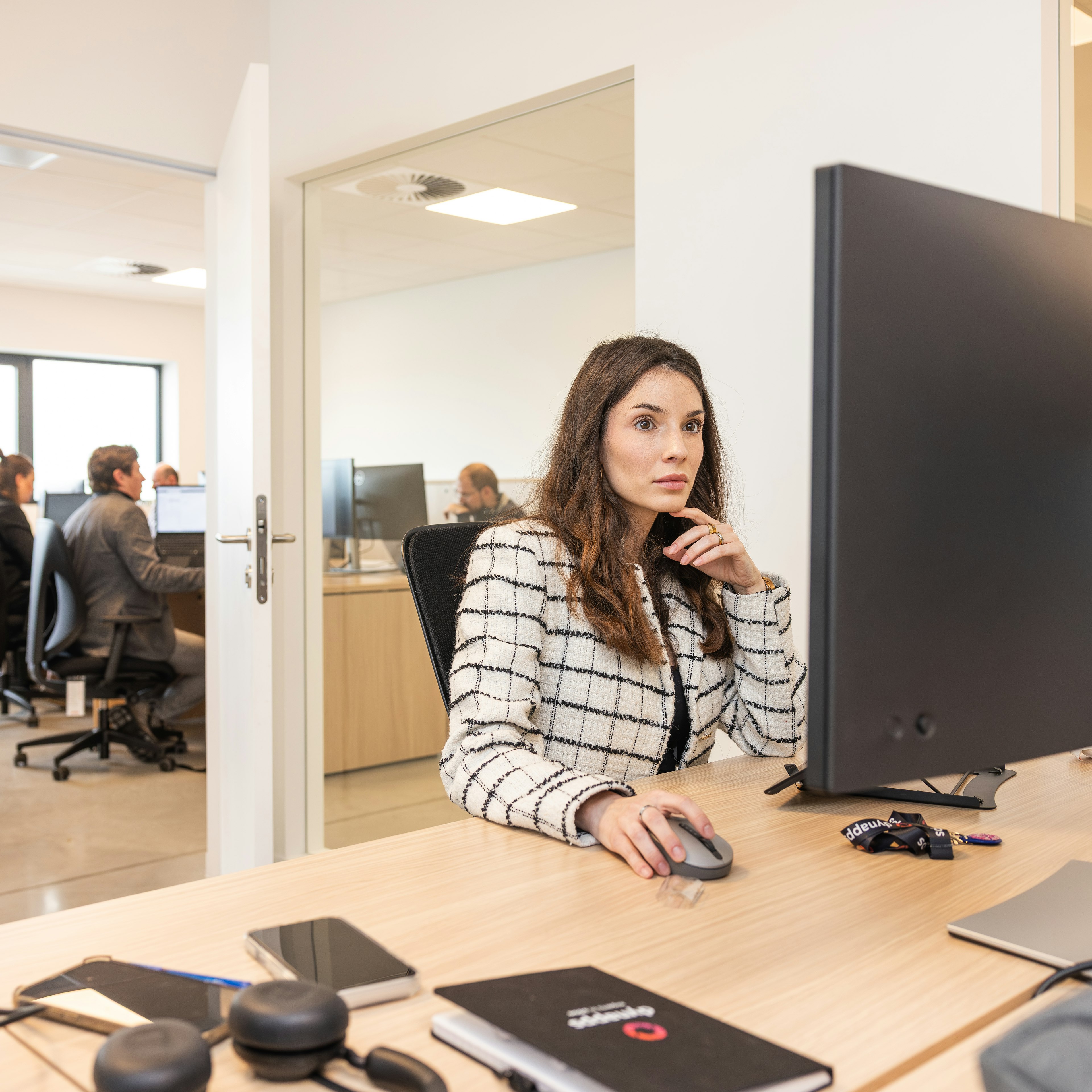 Une femme travaillant devant son écran dans un bureau en open space