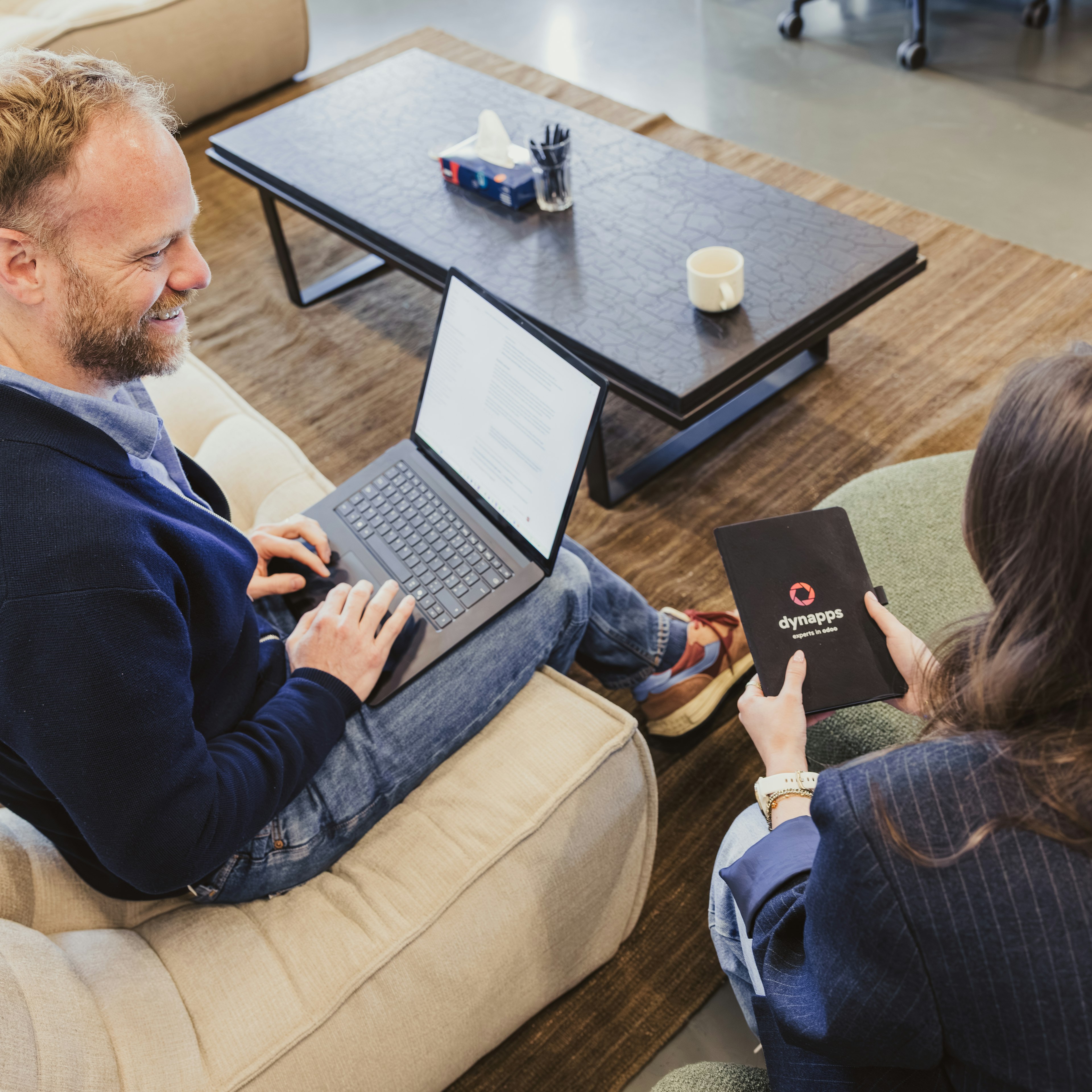 Colleagues with laptop and Dynapps notebook on a sofa