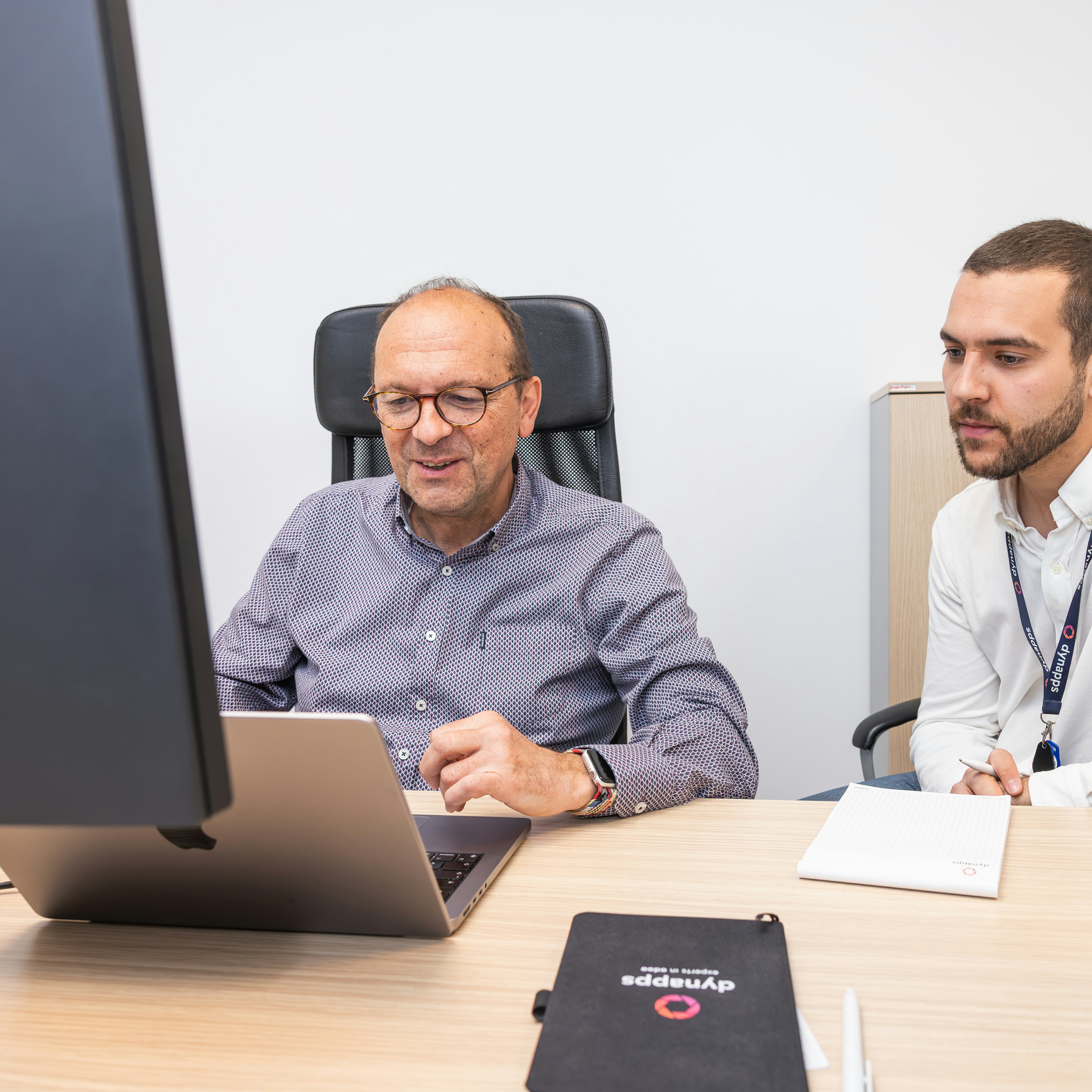 Twee Dynapps-collega's bekijken samen een tablet