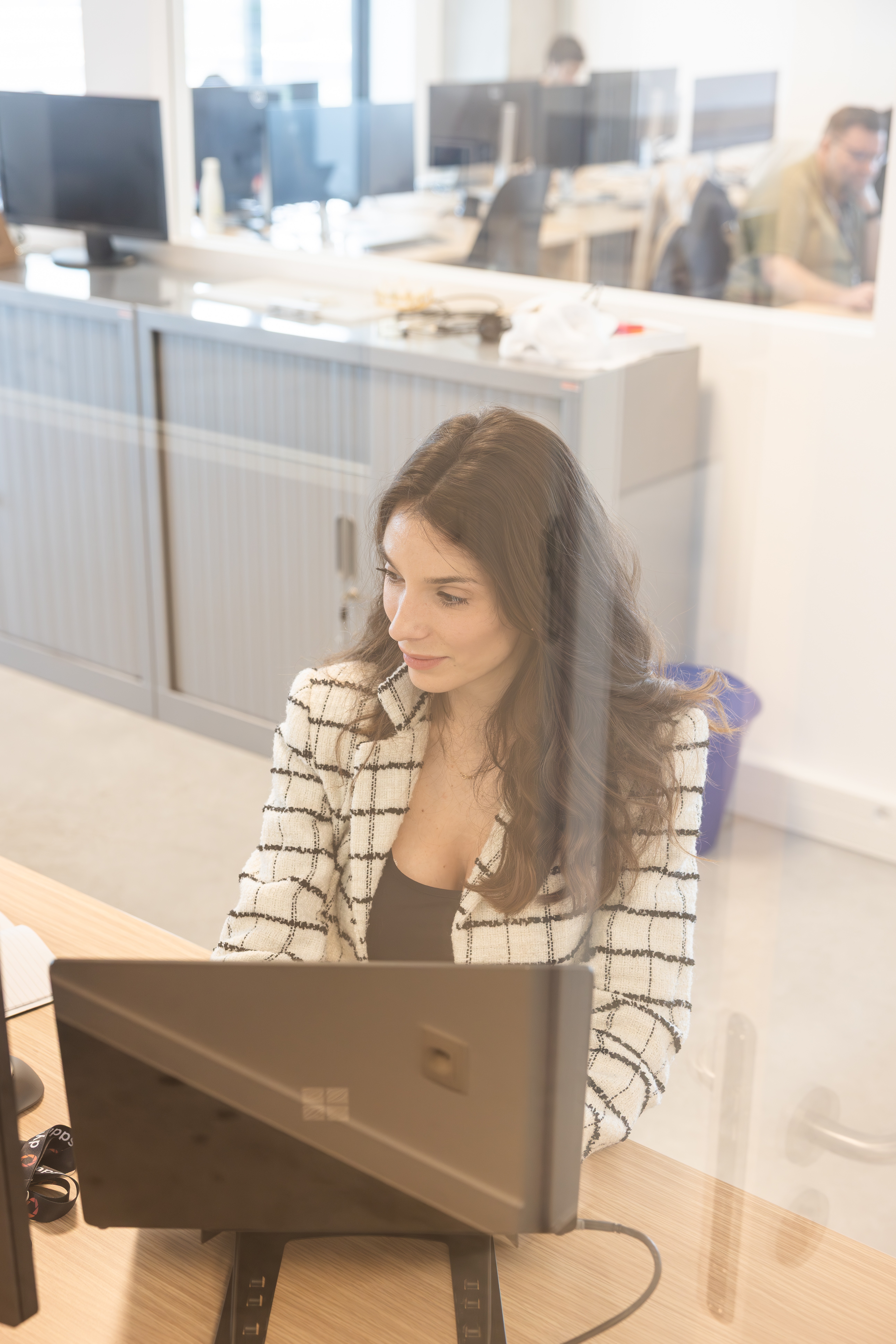 Woman working on a laptop in an open-plan office