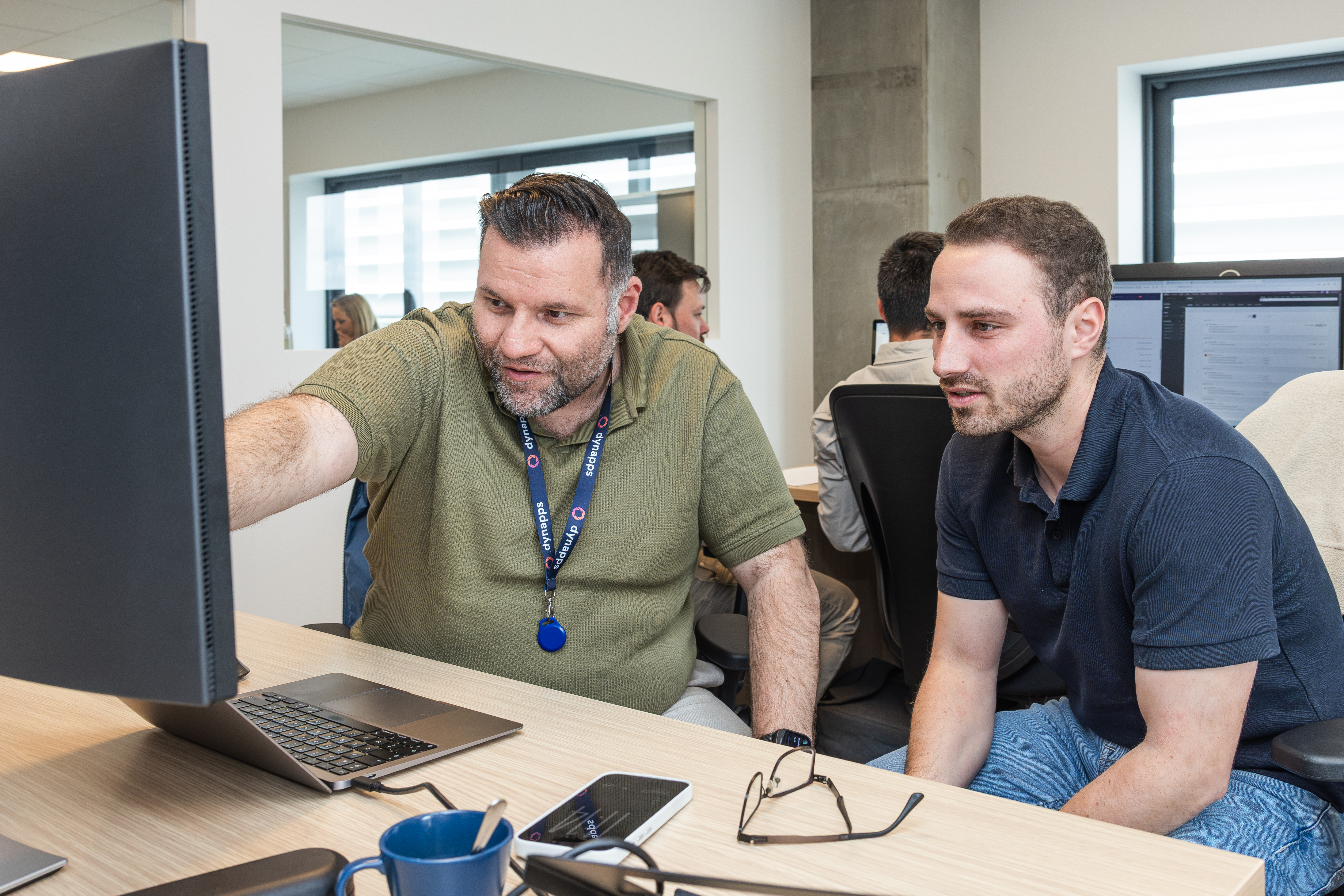 Un collègue de Dynapps qui montre un écran tout en expliquant