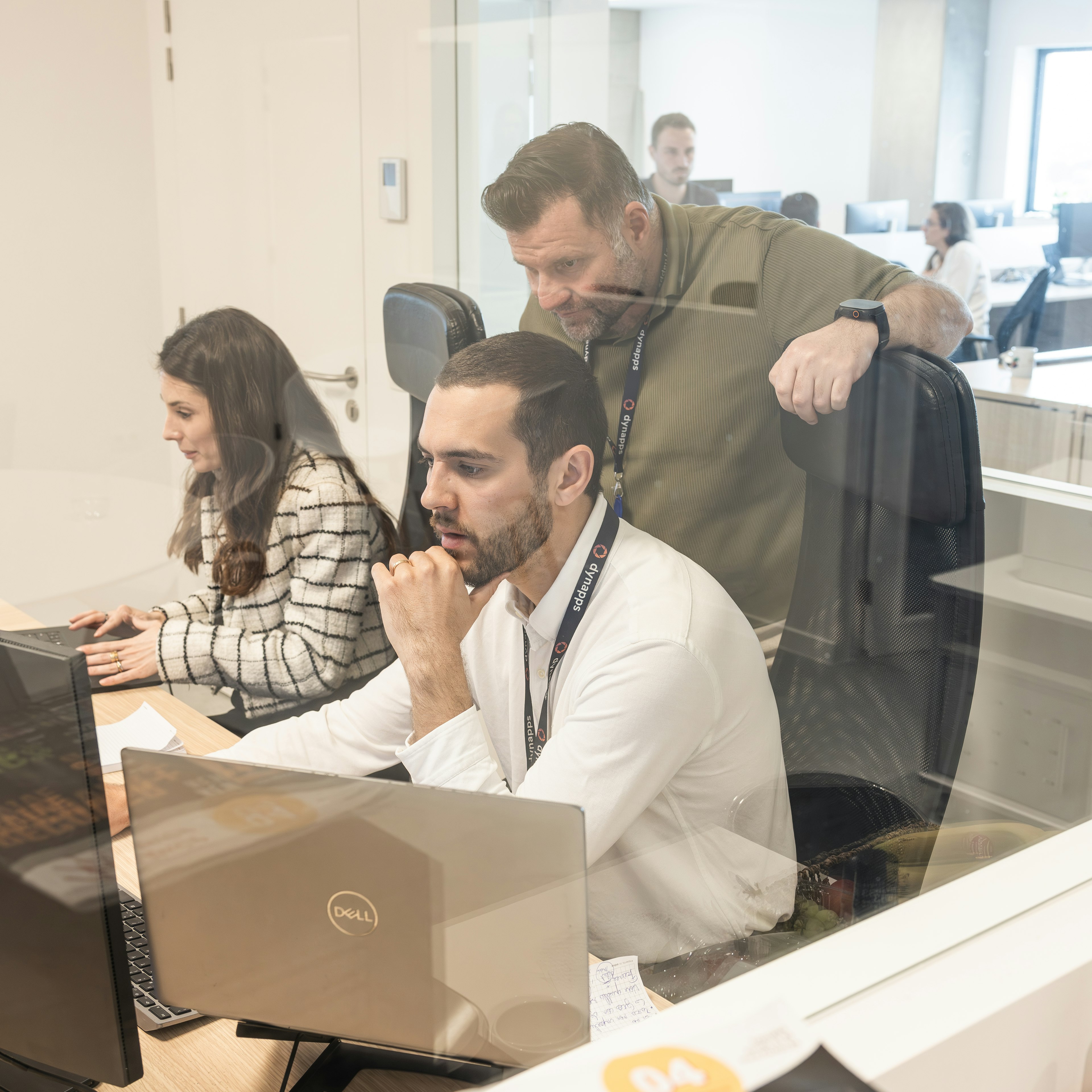 Des consultants de Dynapps examinent ensemble un écran au bureau