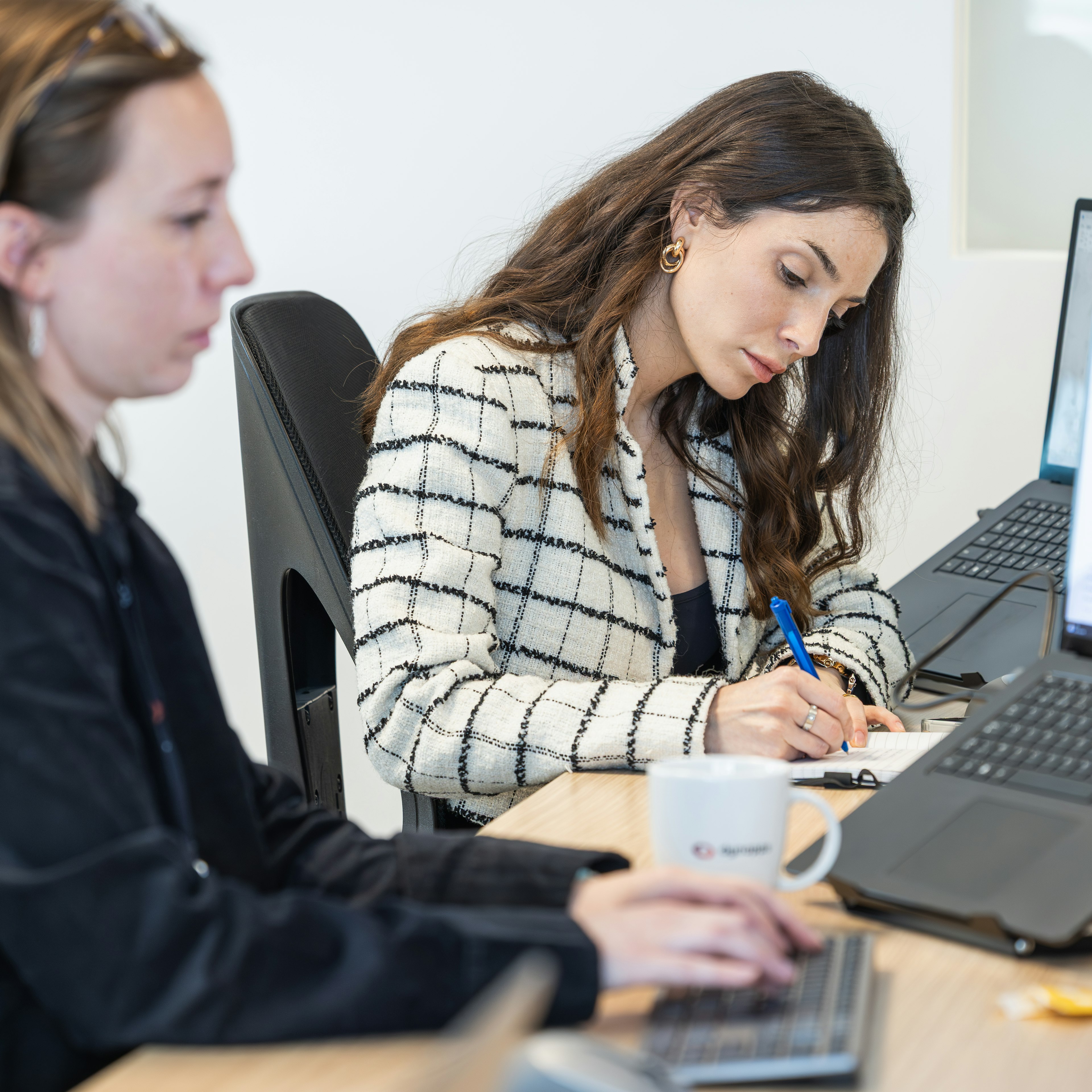 Deux consultants penchés sur leur travail à leur bureau, devant leur ordinateur portable