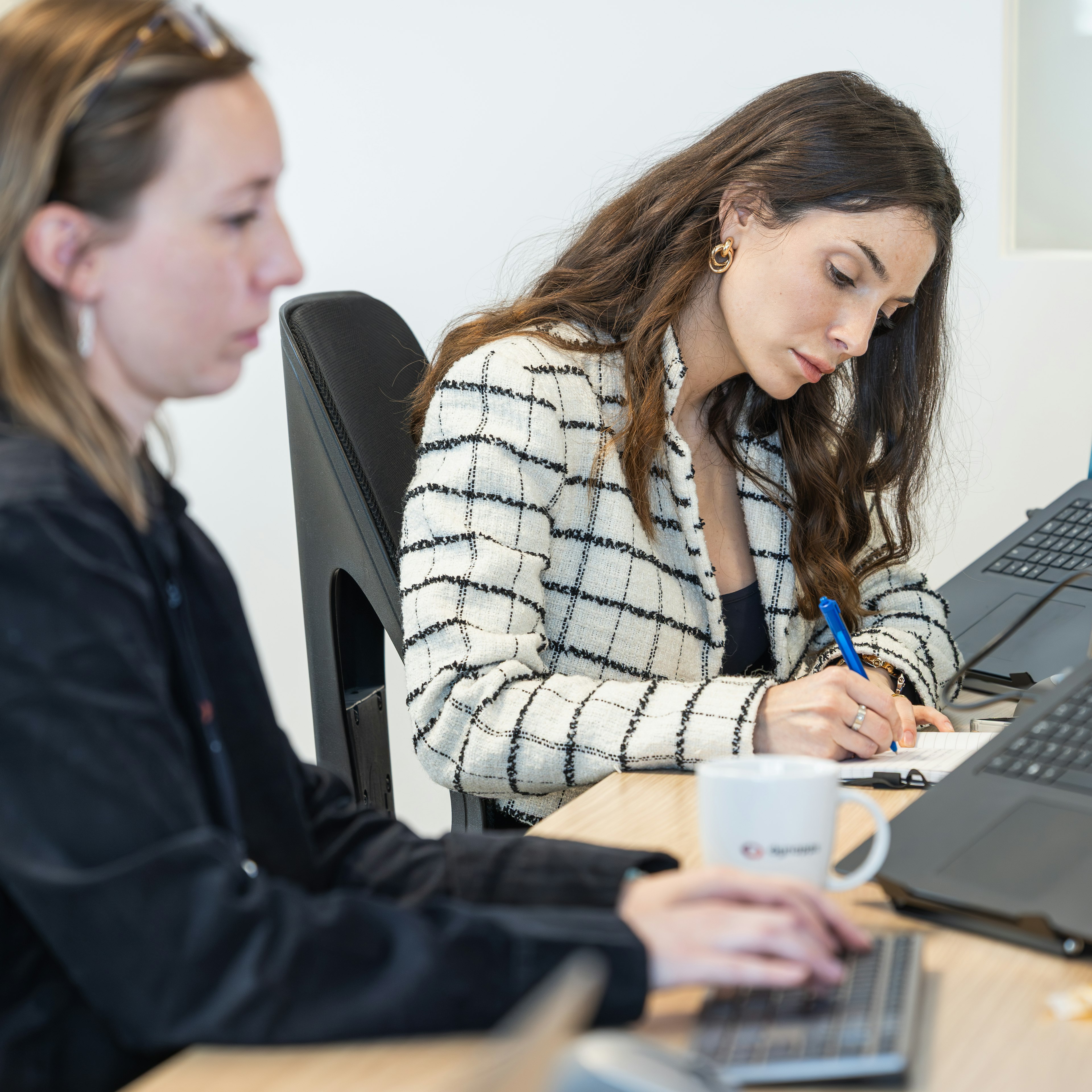Two Dynapps consultants working at their desks with laptops