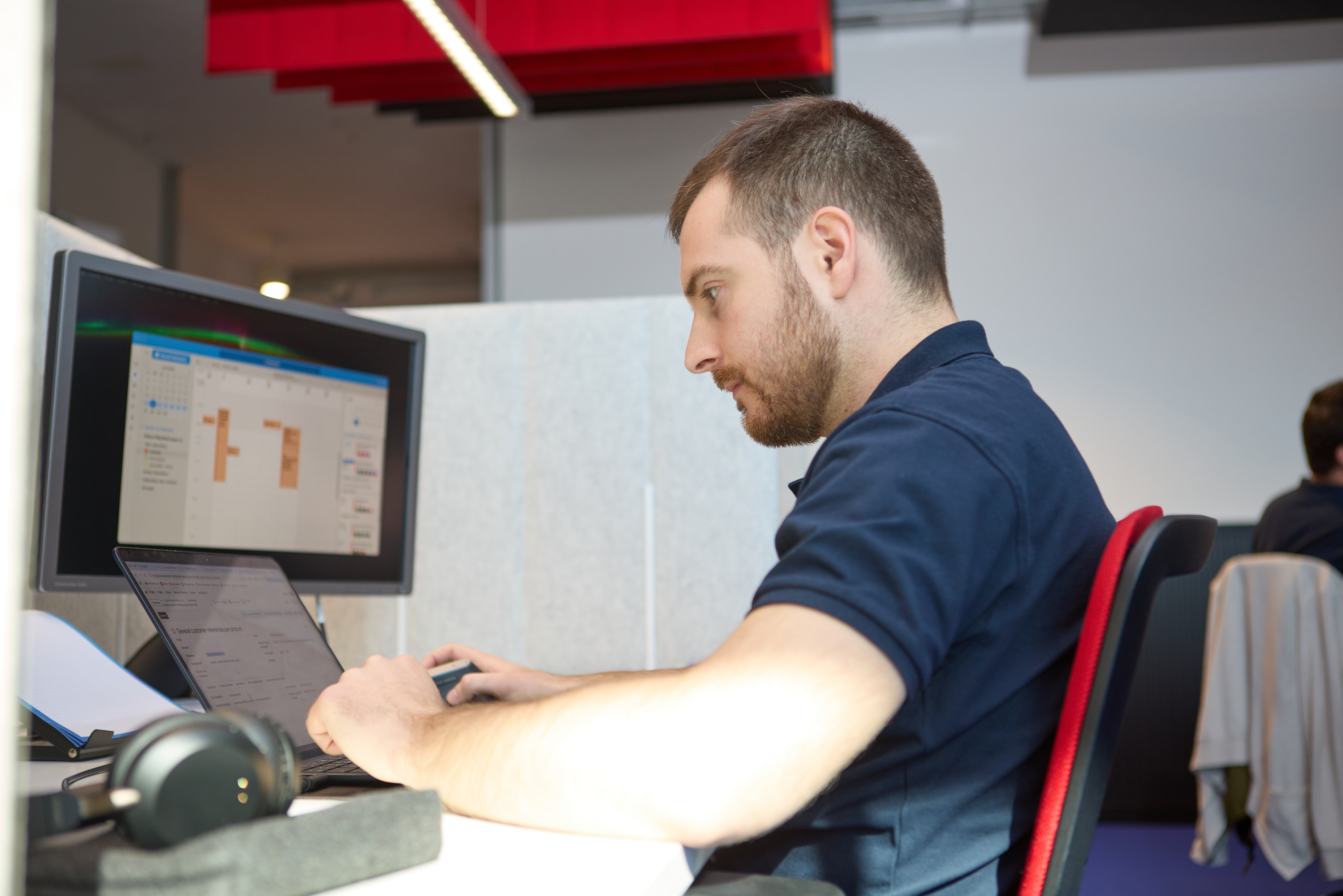 A man sitting at a desk, working on a computer