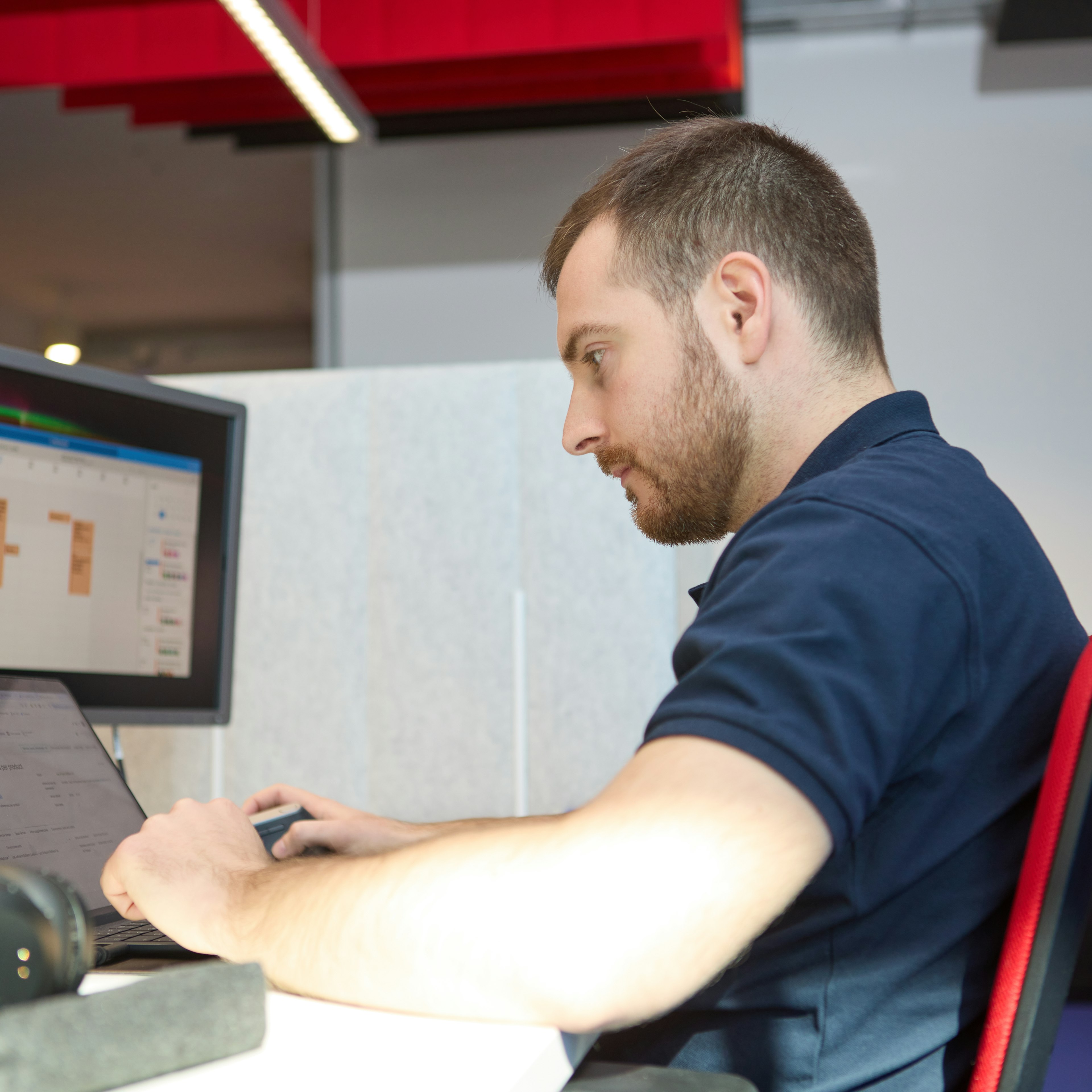 A man sitting at a desk, working on a computer