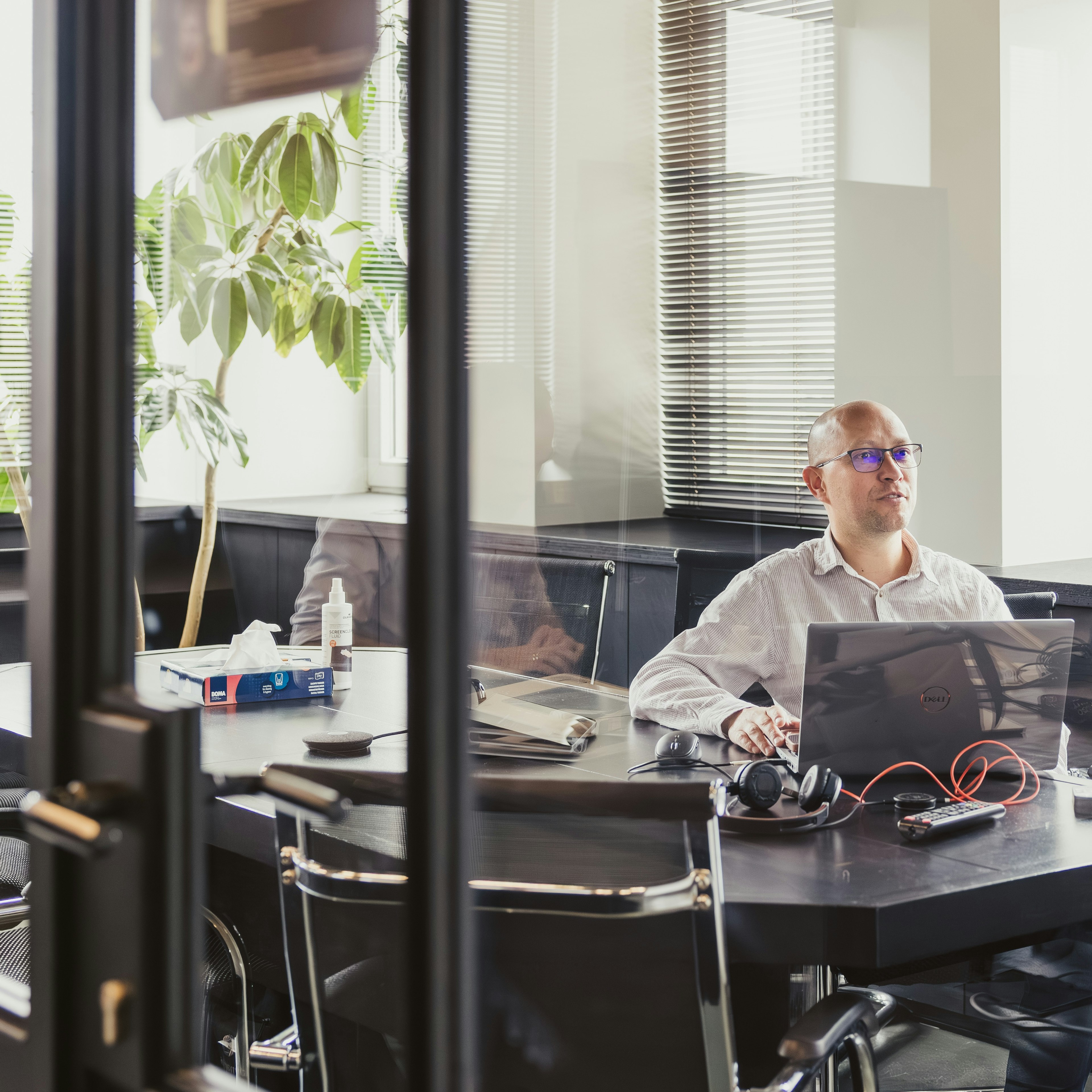 Consultant on a call alone in a glass meeting room