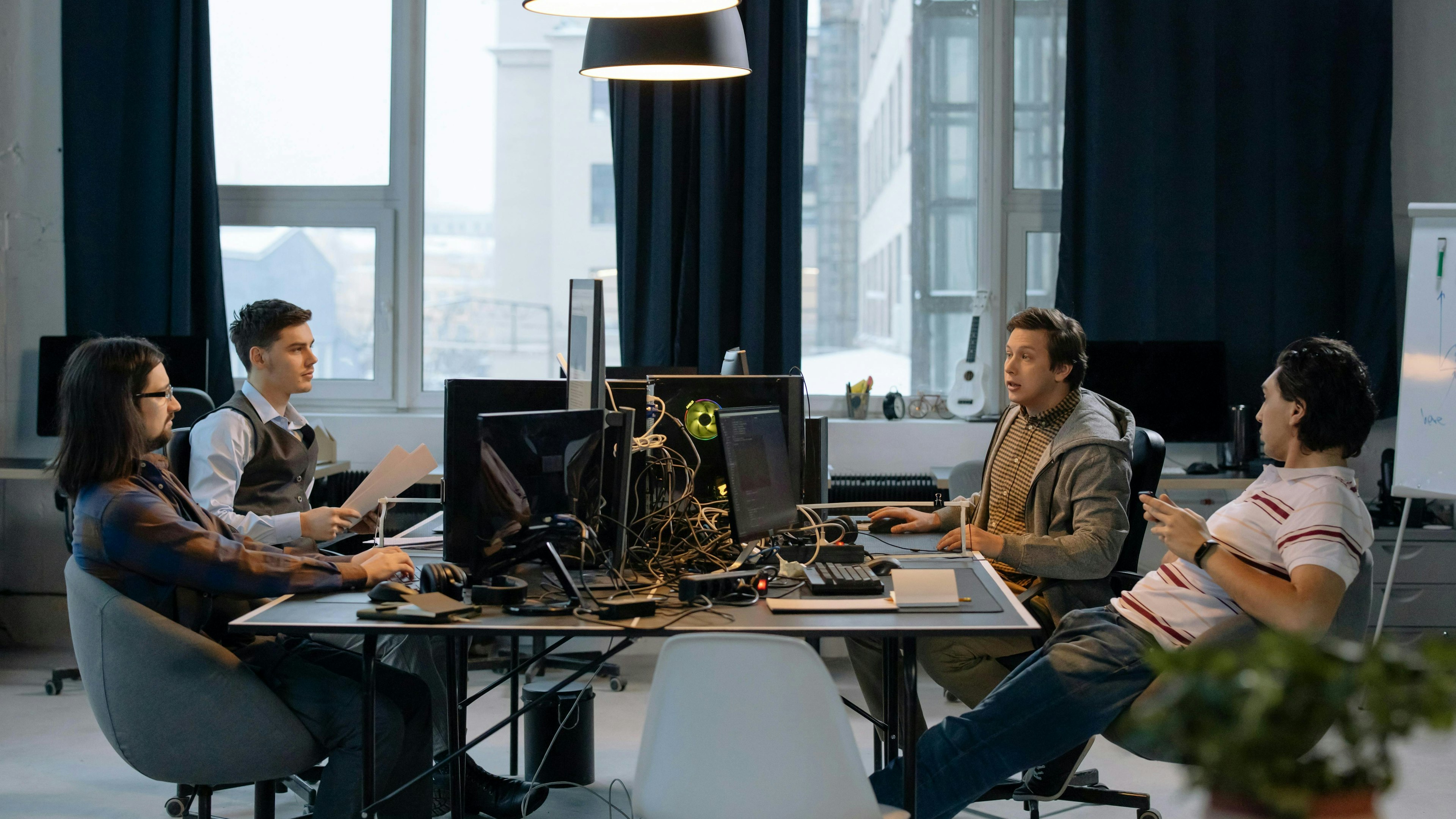 A modern office space featuring meeting rooms, black furniture, and contemporary furnishings designed to foster business collaboration.