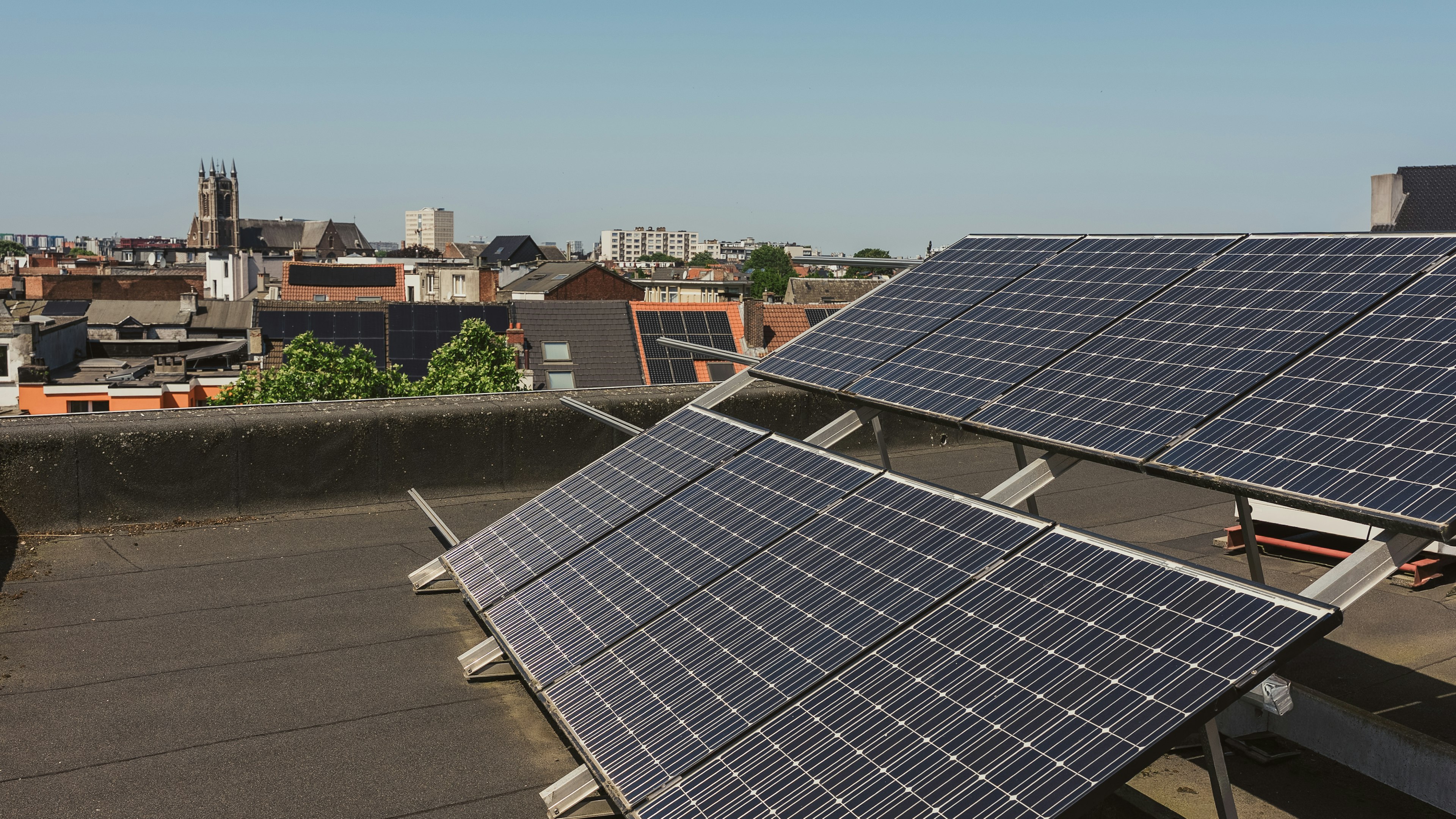 Two Ecopower colleagues on a rooftop beside solar panels