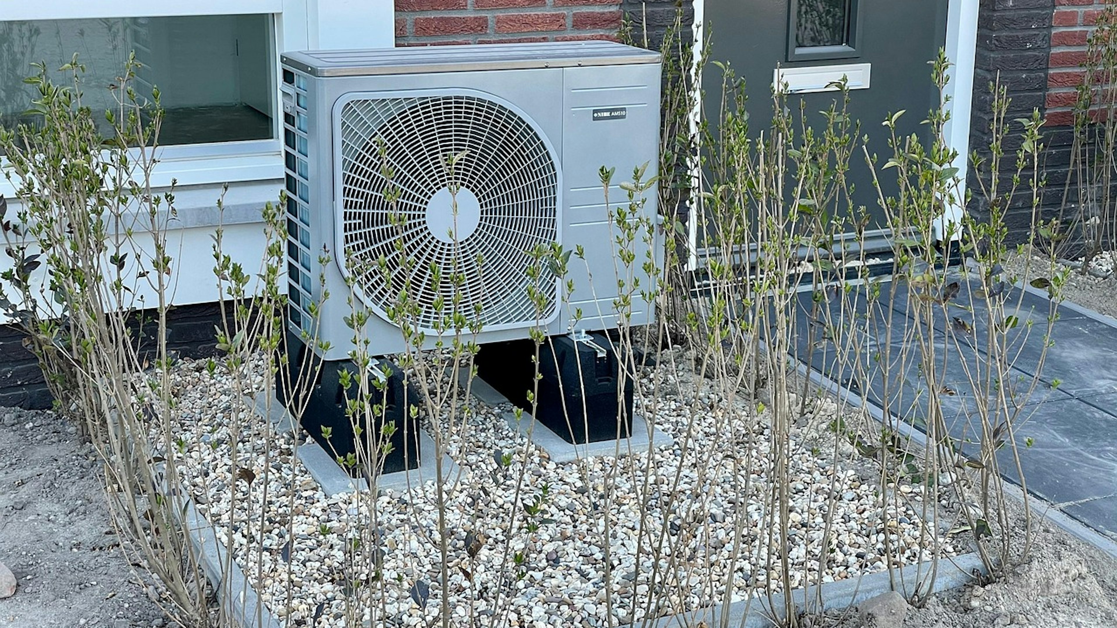 Outdoor heat pump unit installed in front of a house