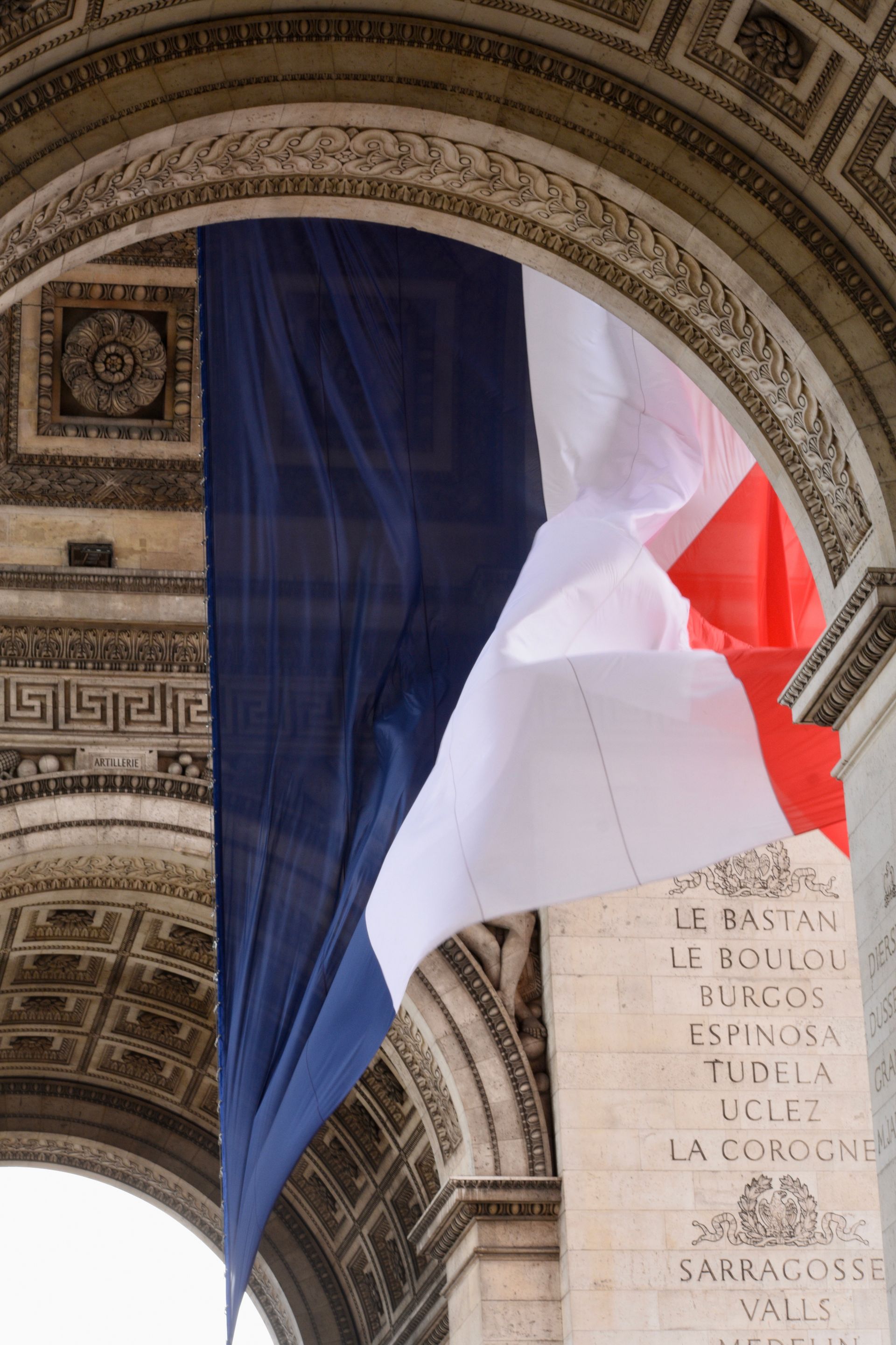 French flag under the Arc de Triomphe in Paris