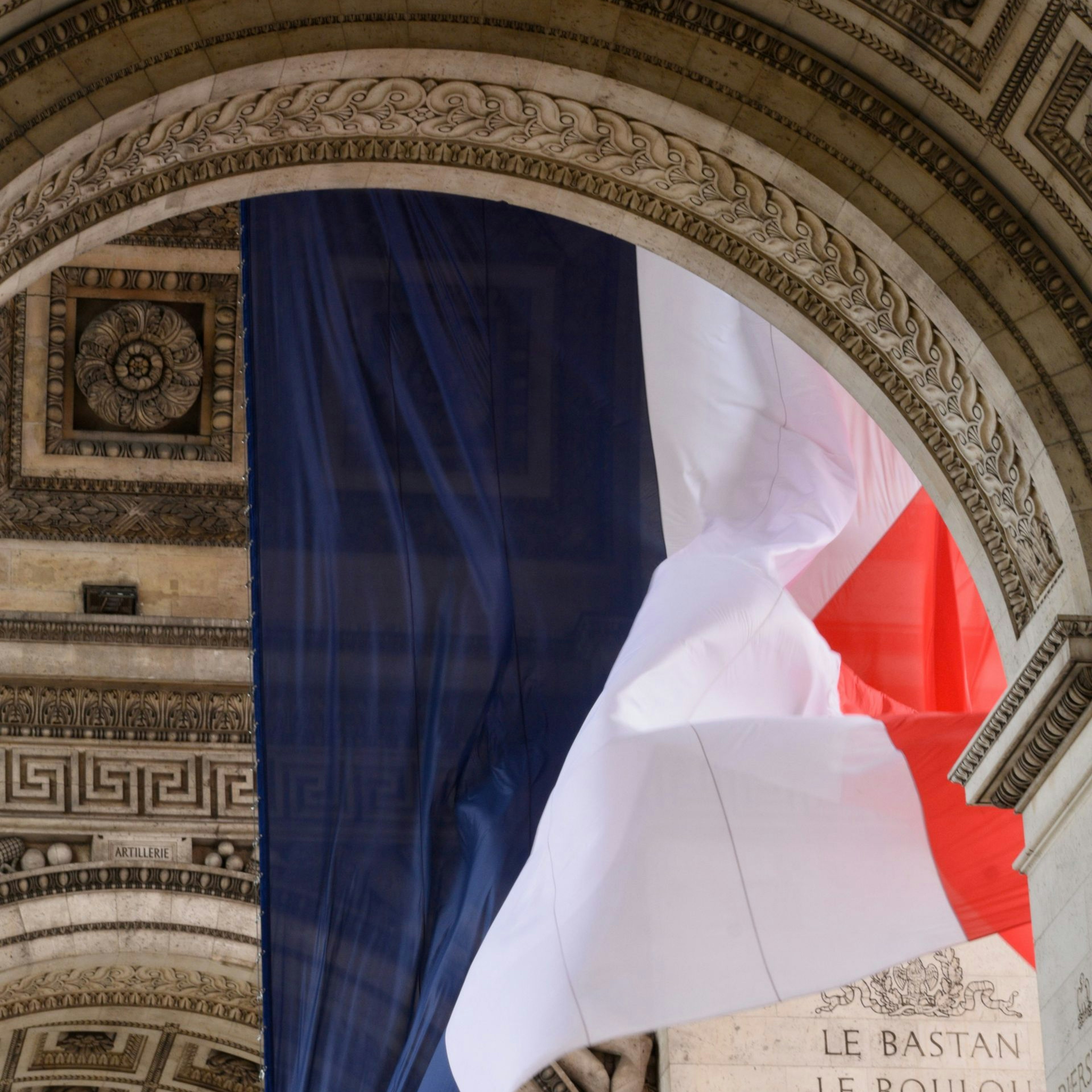 French flag under the Arc de Triomphe in Paris