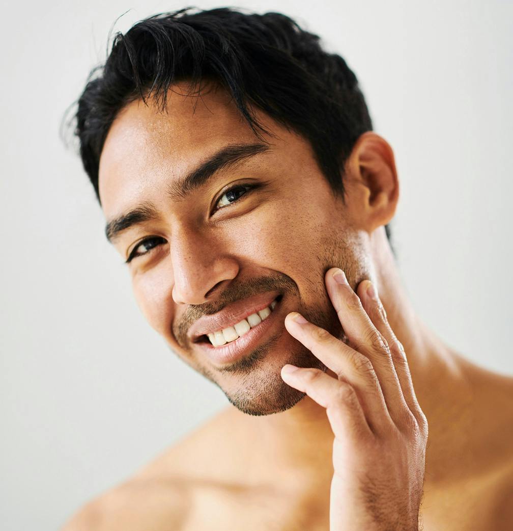 man smiling touching face