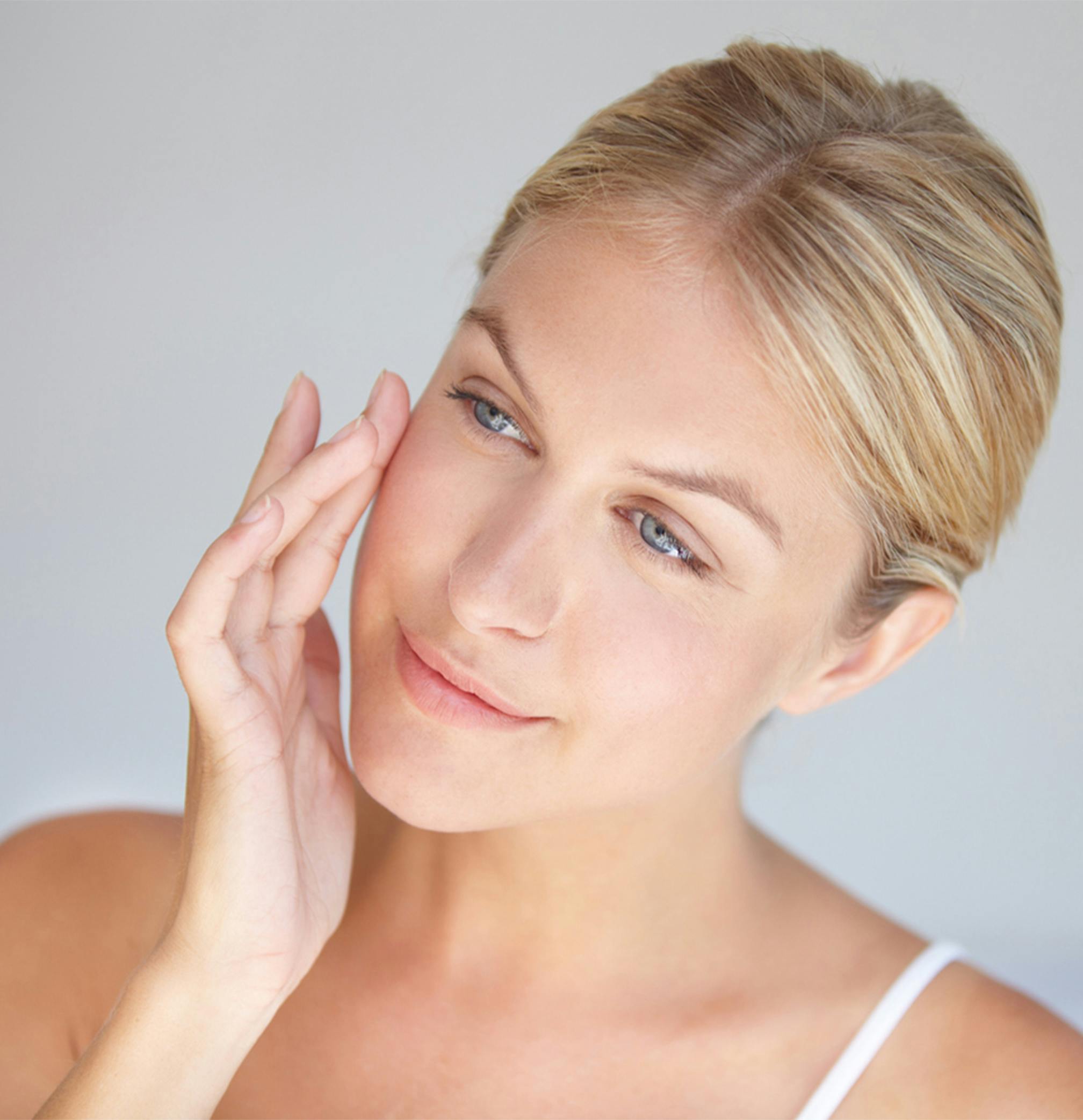 woman looking to the side touching face