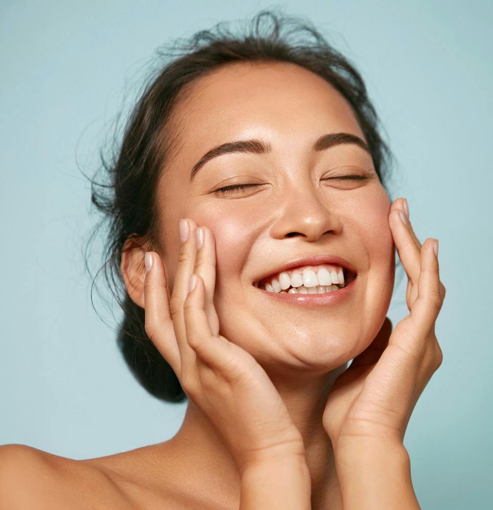 woman smiling touching face