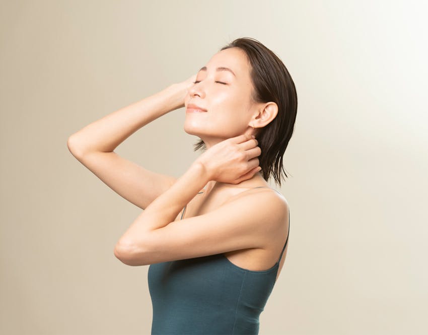 woman touching neck and head