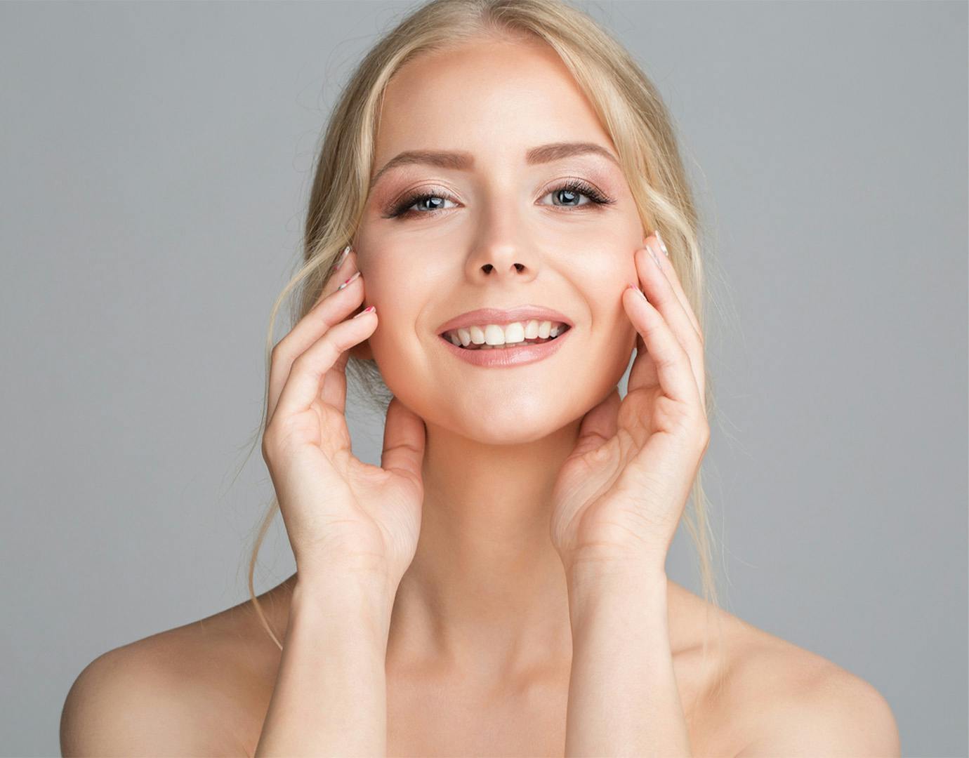 woman smiling touching cheeks