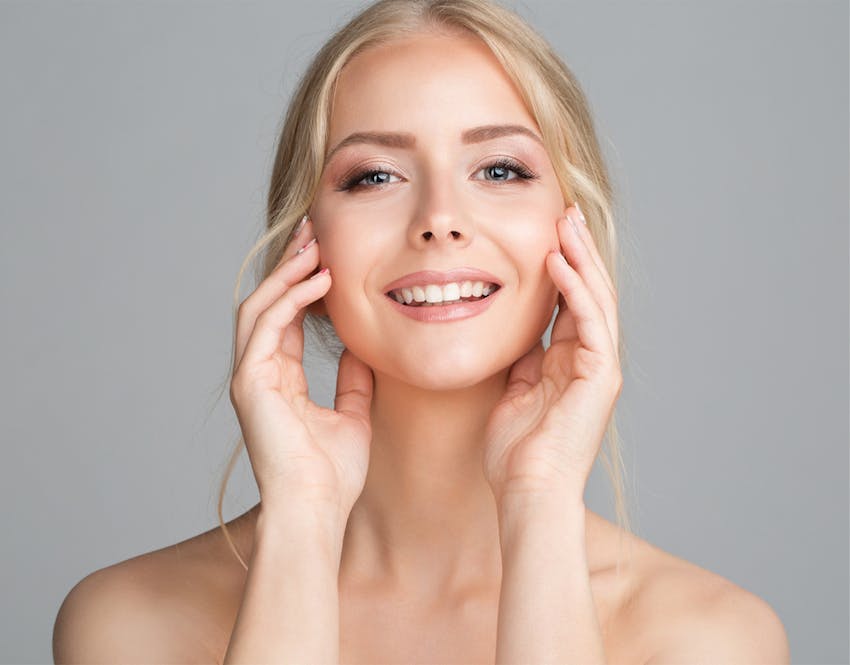 woman smiling touching cheeks